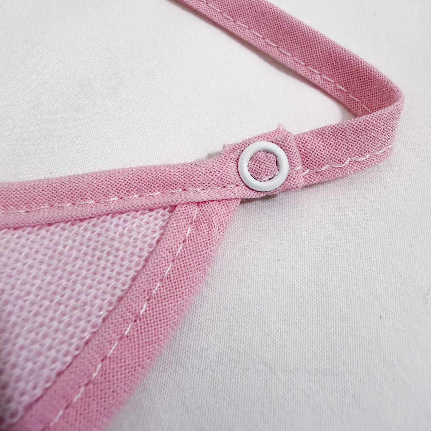 Pormenor de babete liso com lacinho rosa