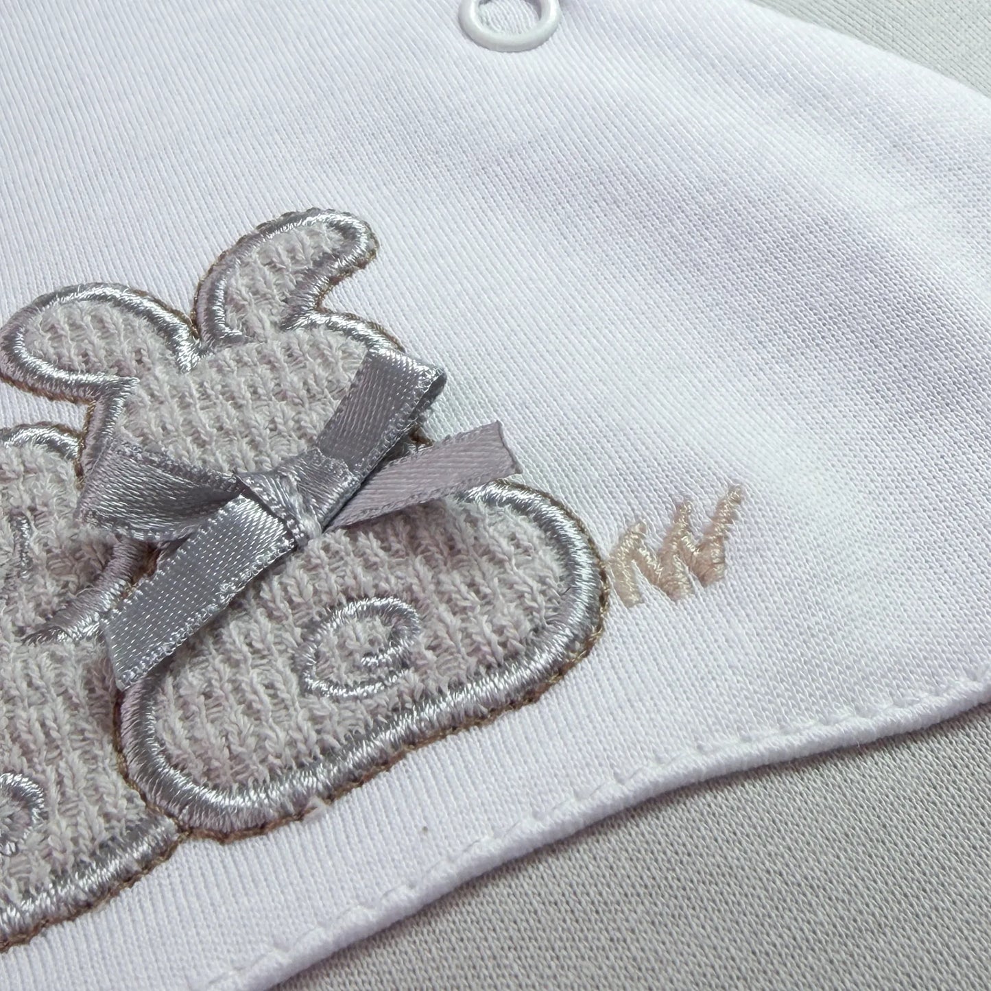 Pormenor de babygrow de algodão com motivo coelhos tricot com lacinho cinza