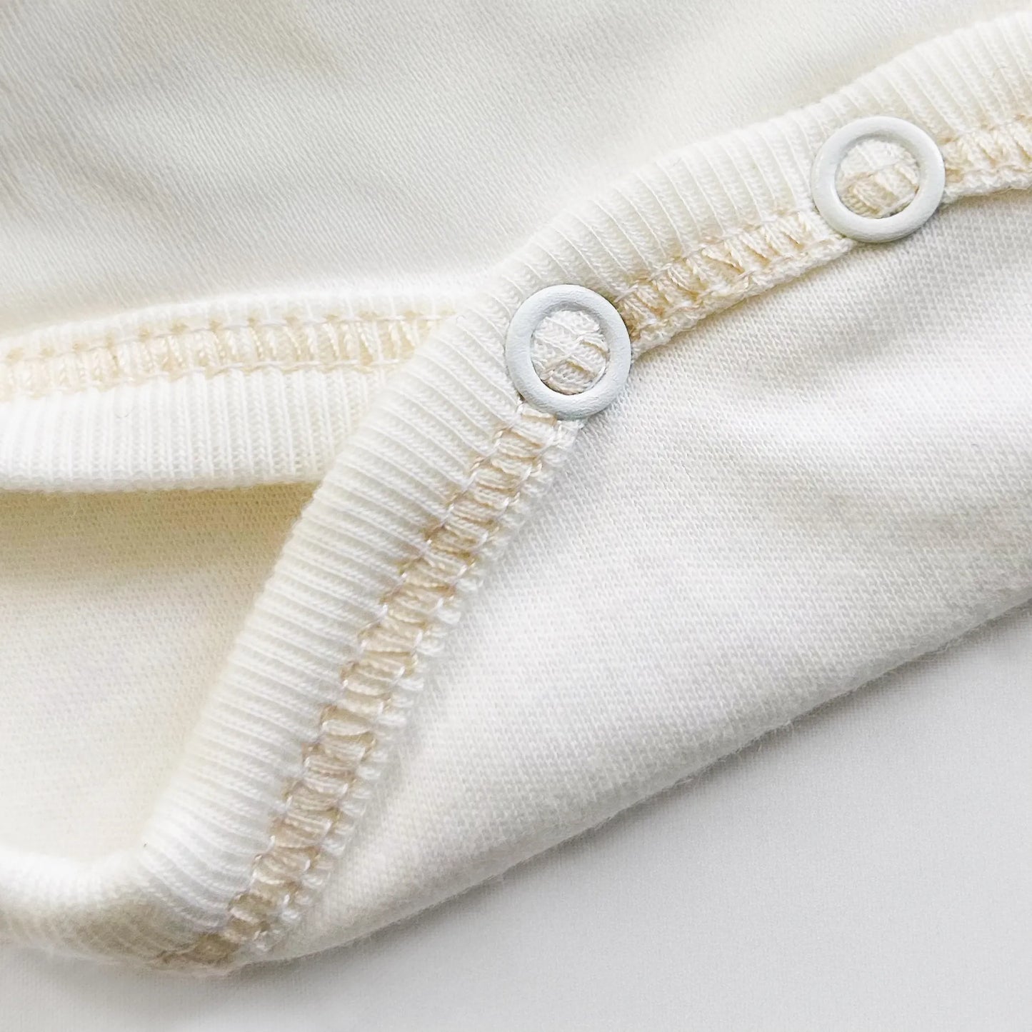 Pormenor de body de trespasse com collant cardado com motivo coelhos tricot com lacinho bege