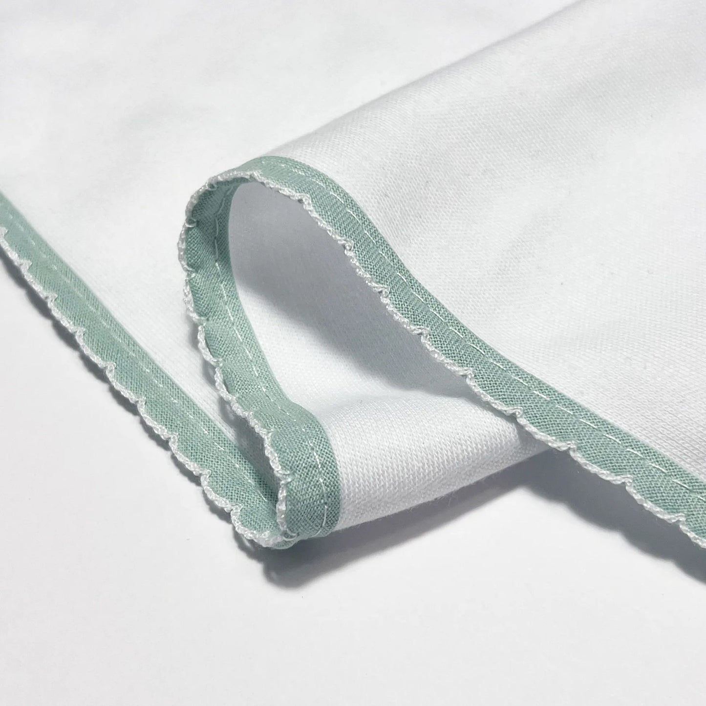 Pormenor de fralda com motivo ursinhos tricot e lacinho verde