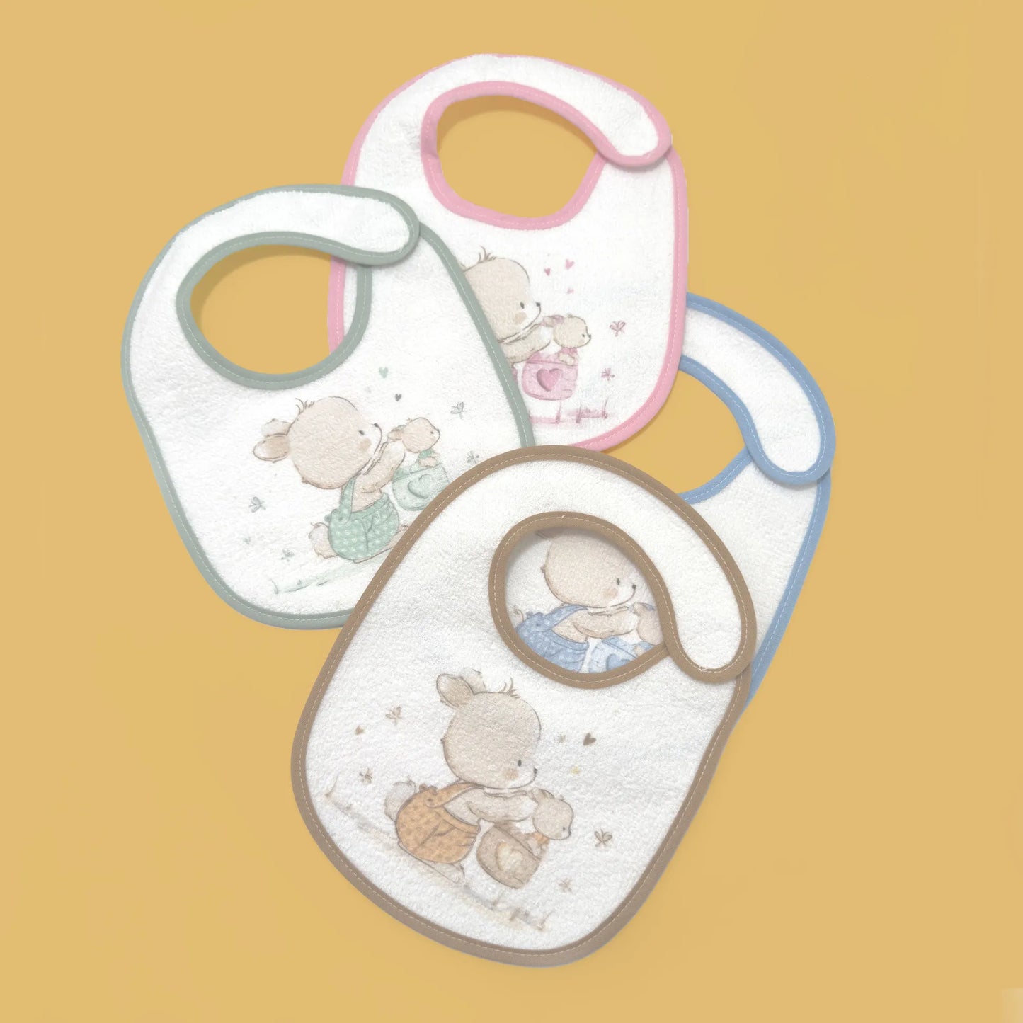 Babetes impermeáveis com motivo coelhinho na cesta rosa, azul, bege e verde