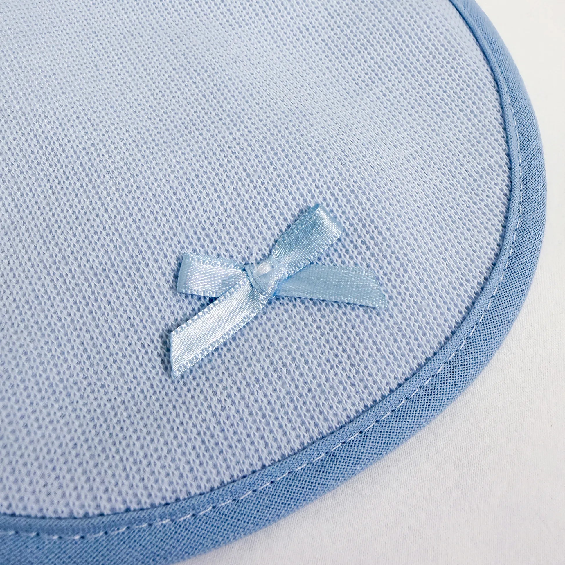 Pormenor de babete liso com lacinho azul