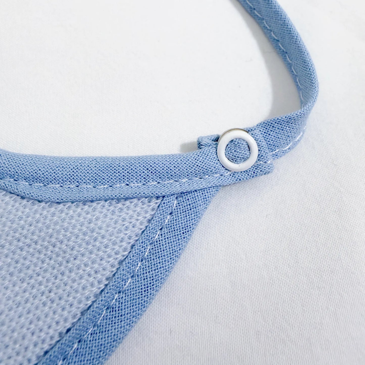 Pormenor de babete liso com lacinho azul