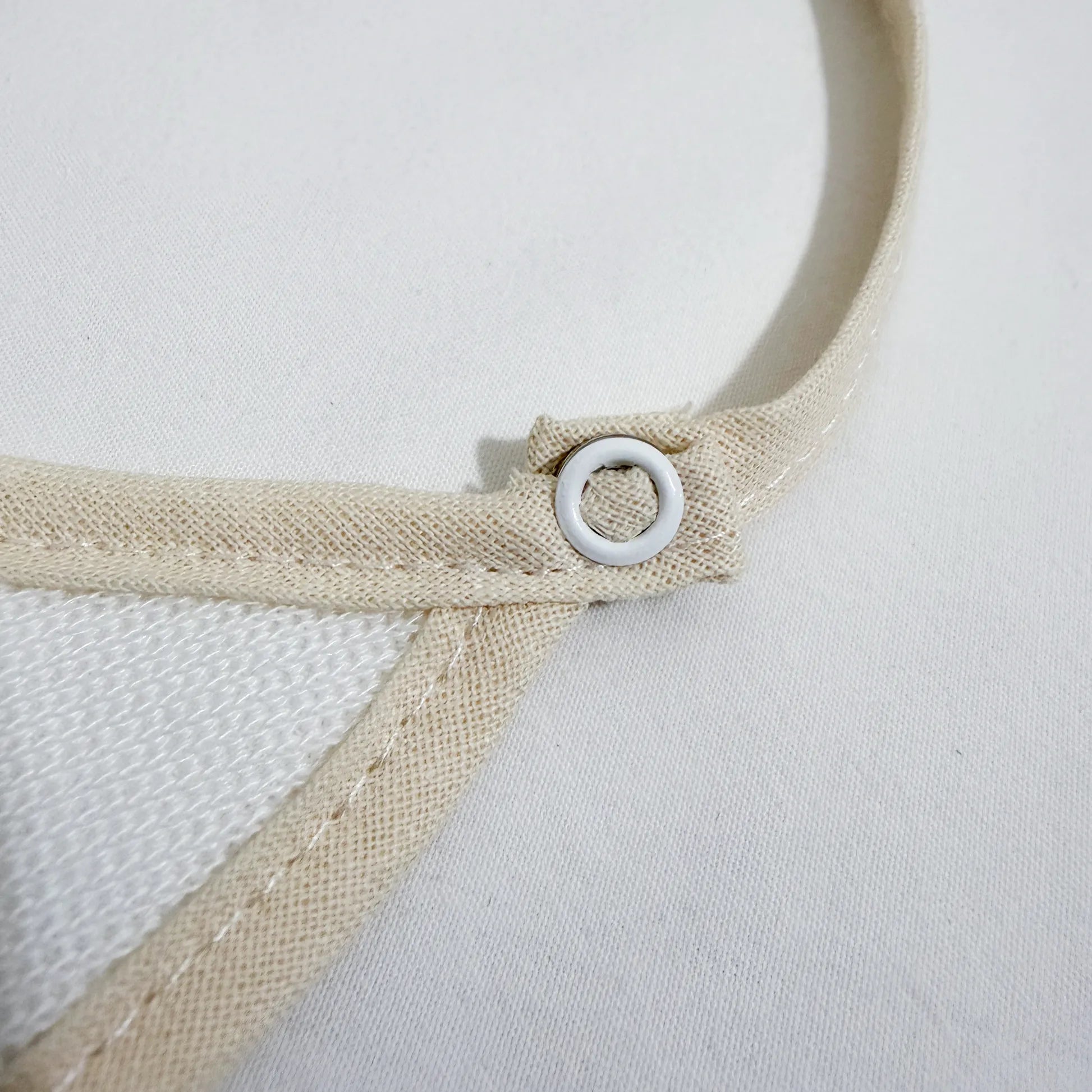 Pormenor de babete liso com lacinho pérola