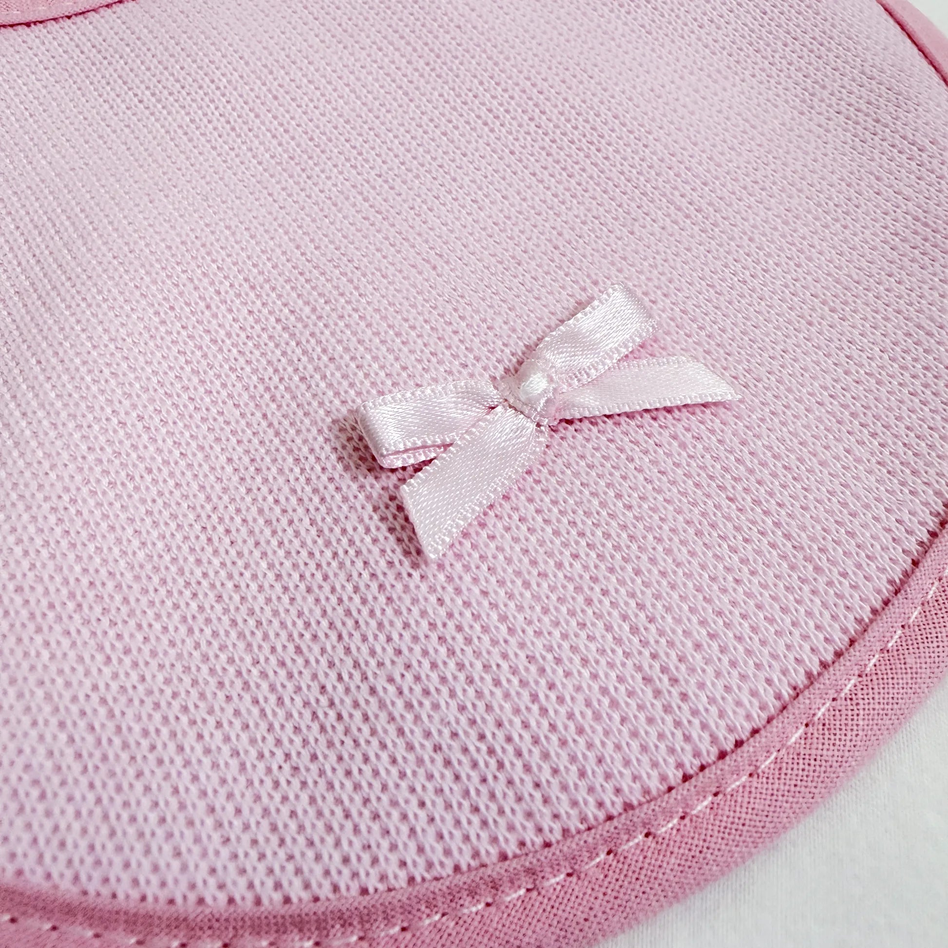 Pormenor de babete liso com lacinho rosa