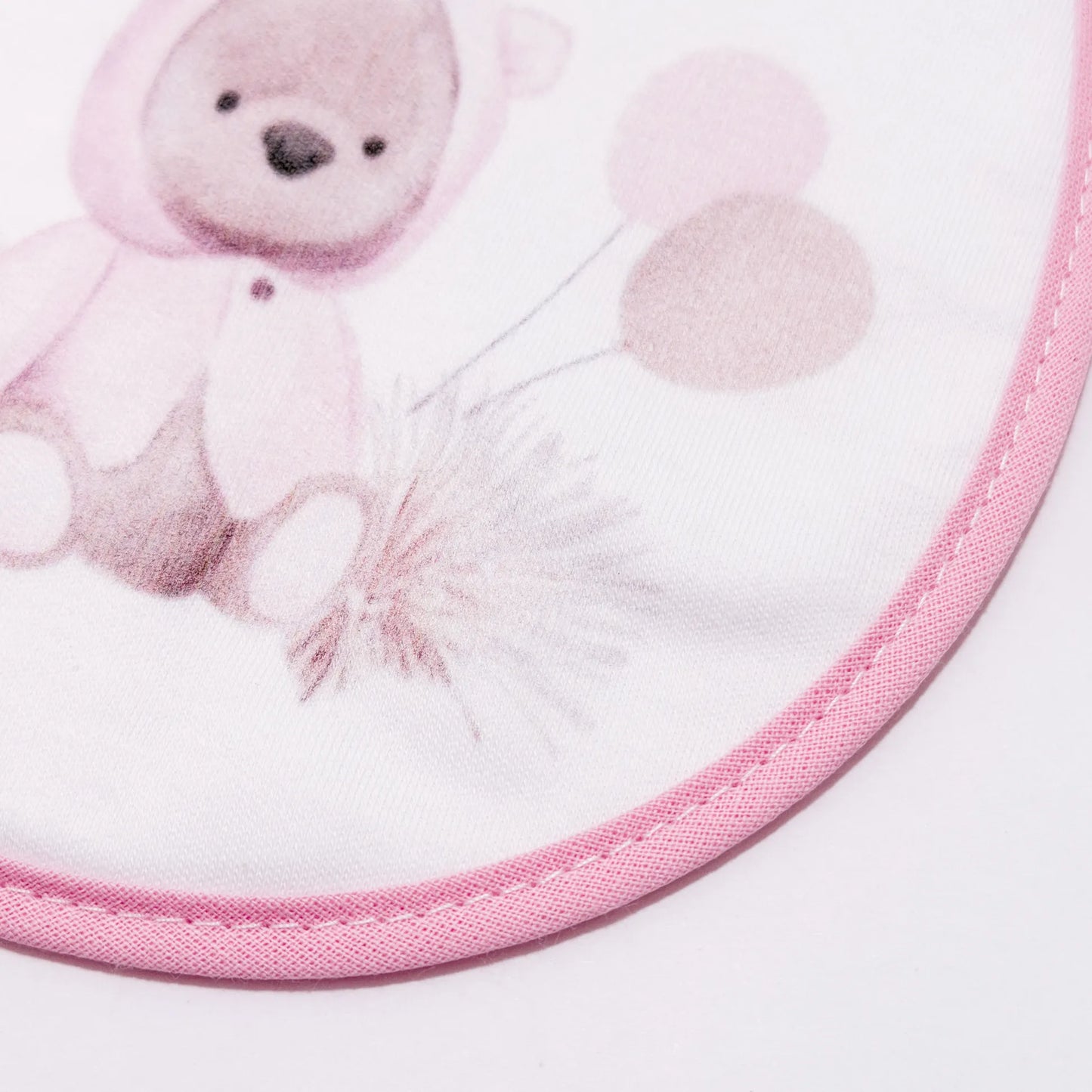 Pormenor de babete com motivo ursinho com capuz rosa