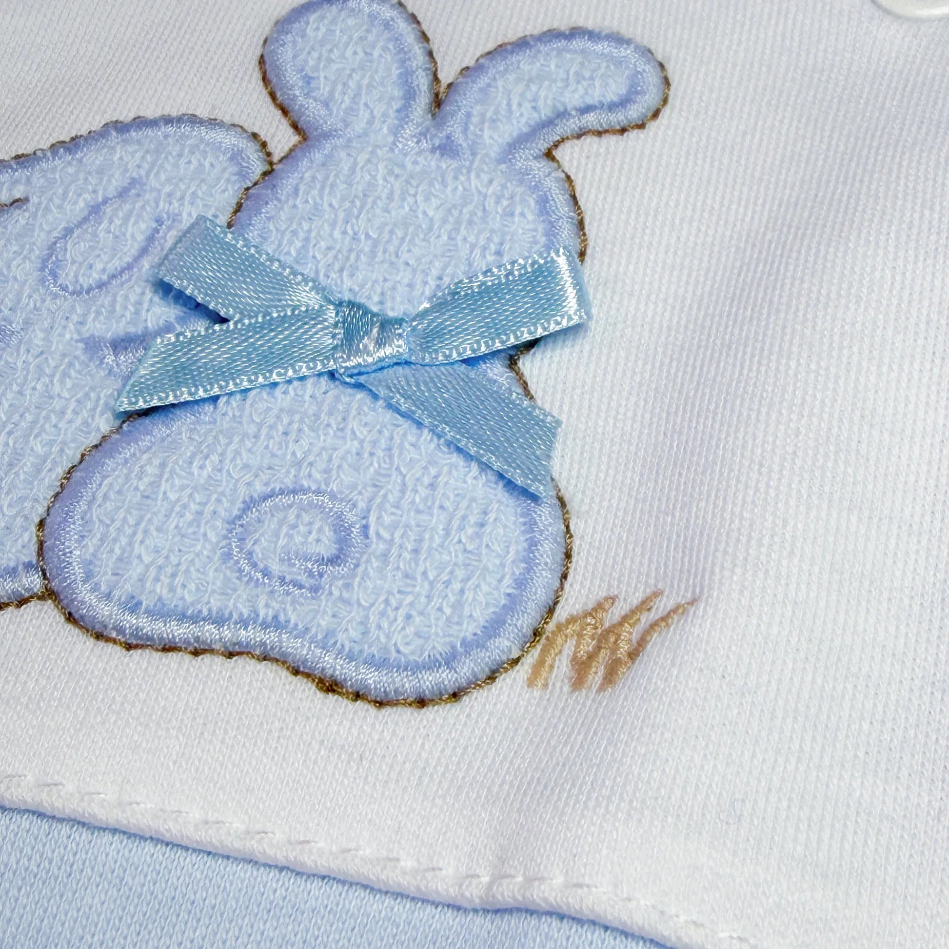 Pormenor de babygrow de algodão com motivo coelhos tricot com lacinho azul