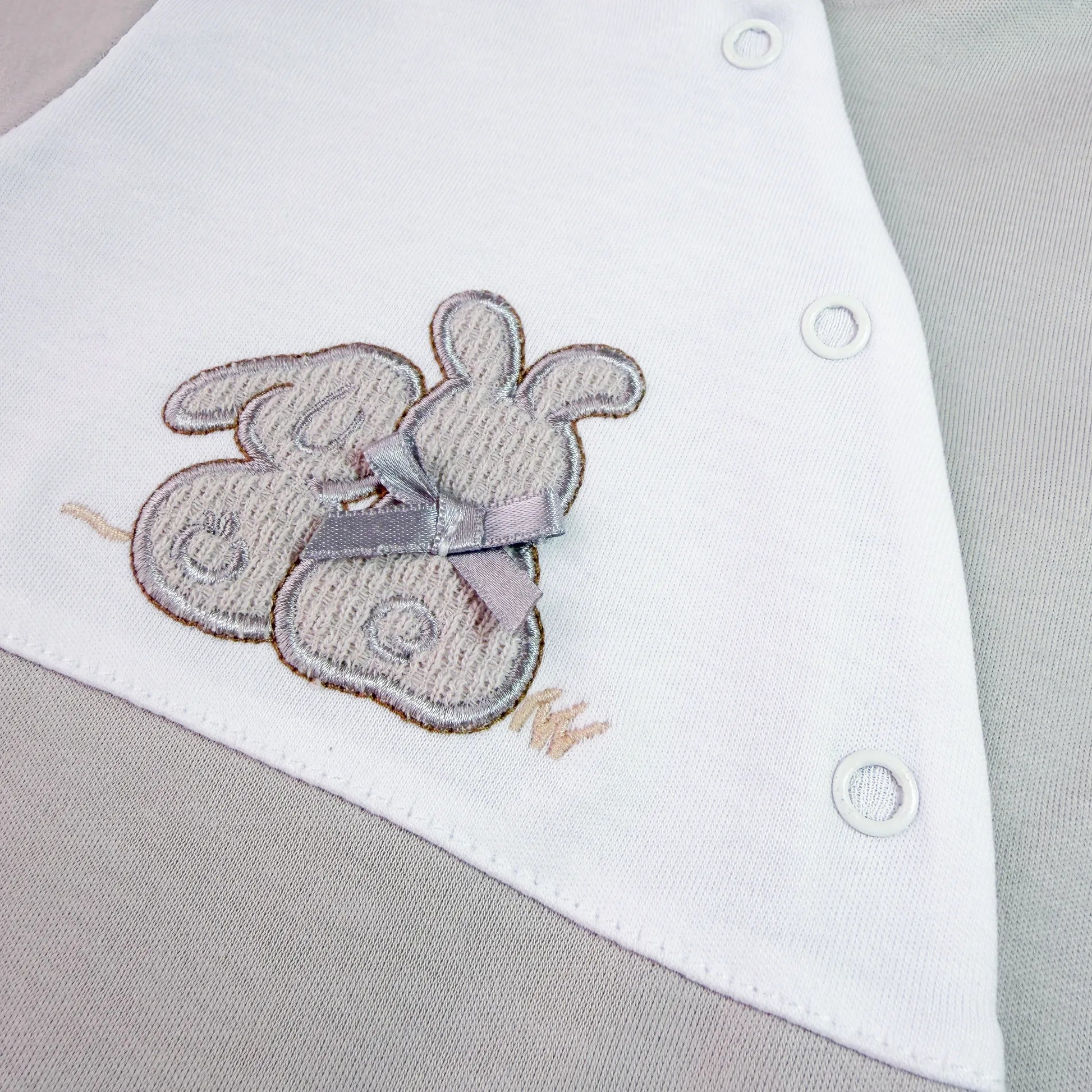 Pormenor de babygrow de algodão com motivo coelhos tricot com lacinho cinza