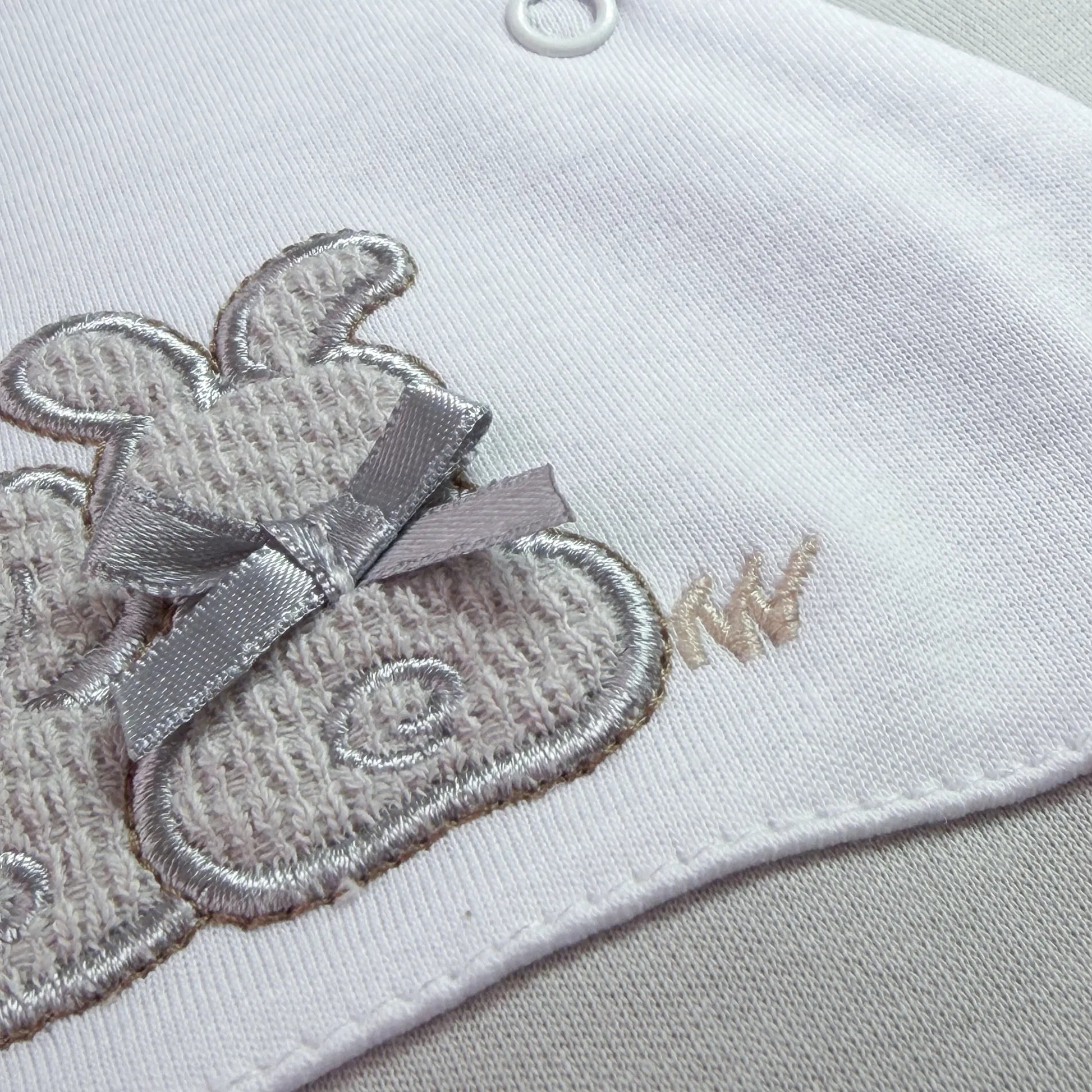 Pormenor de babygrow de algodão com motivo coelhos tricot com lacinho cinza