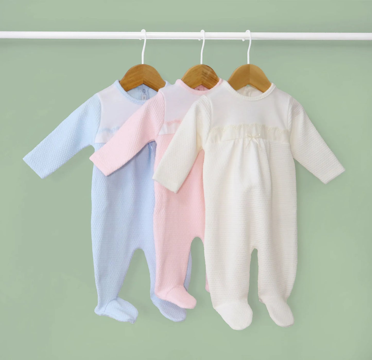 Babygrows com efeito renda e lacinho no peito azul, rosa e pérola