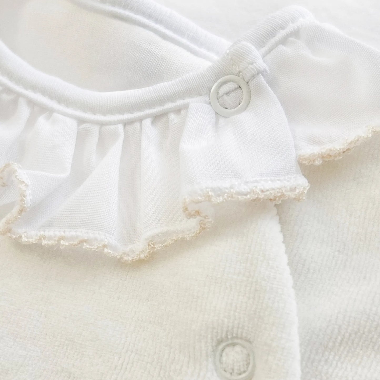 Pormenor de babygrow com gola em folho e motivo ursinho waffle pérola