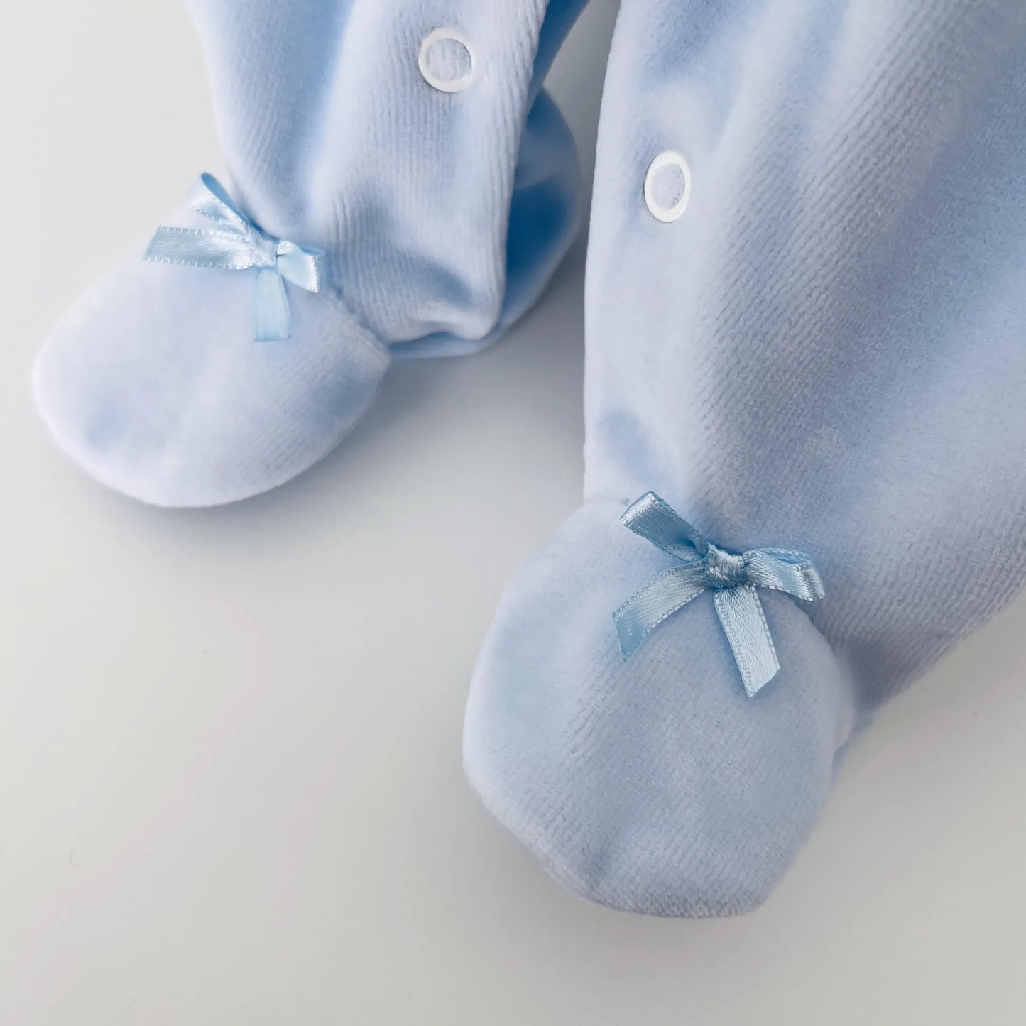 Pormenor de babygrow de menino com bordado losangos azul