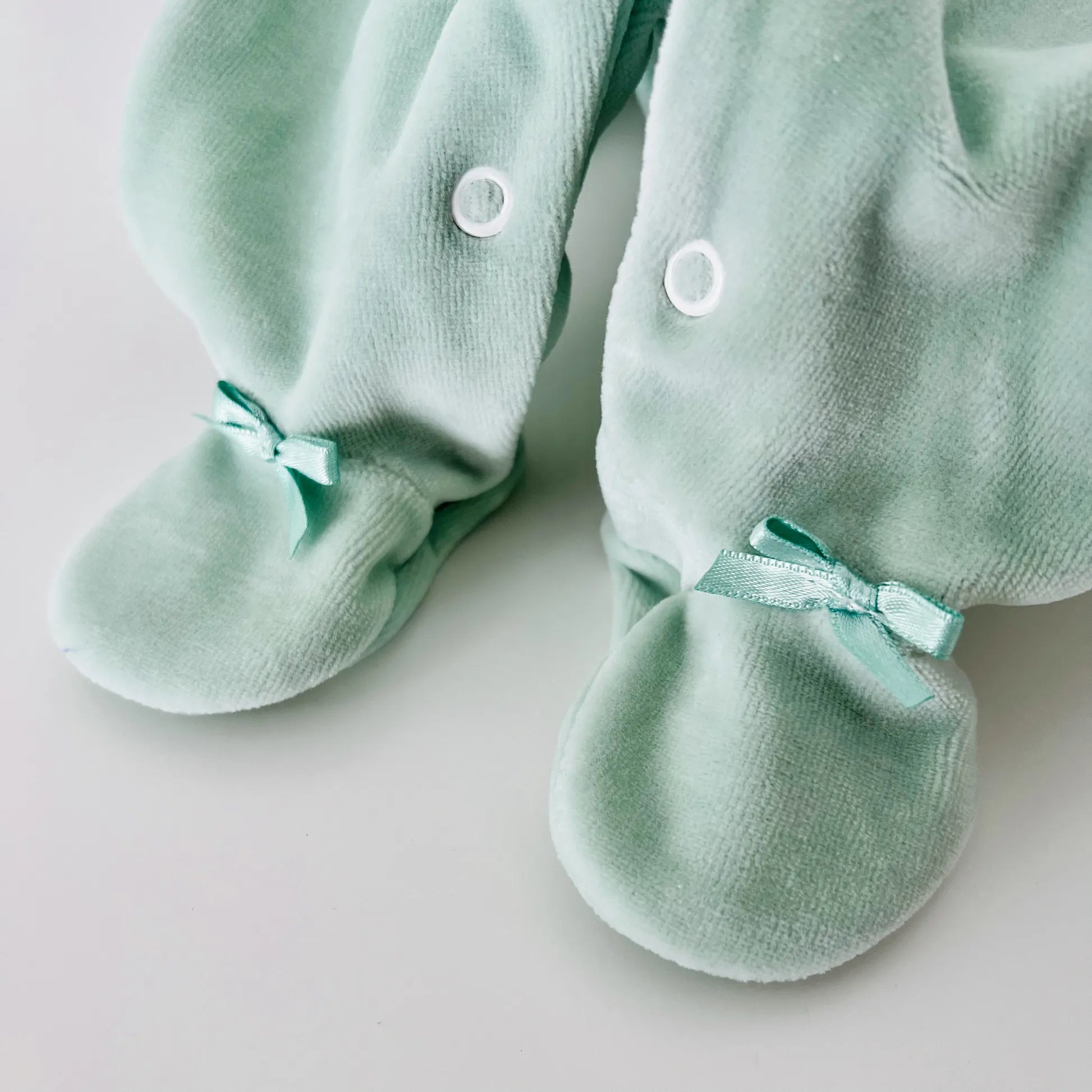 Pormenor de babygrow de menino com bordado losangos verde