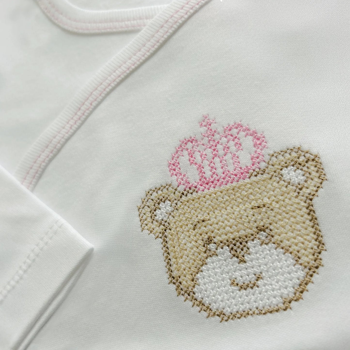 Pormenor de body de trespasse cardado com ursinho bordado em ponto de cruz rosa