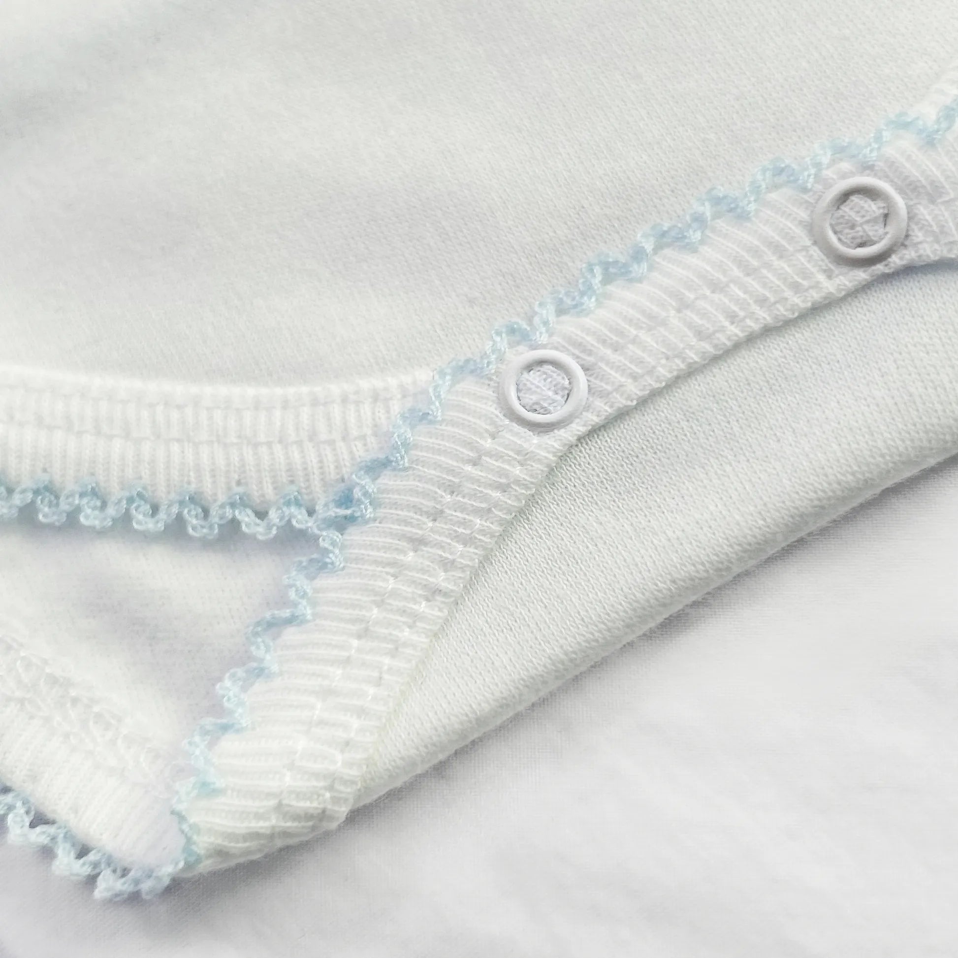 Pormenor de body de trespasse com collant cardado com bordado em redor azul