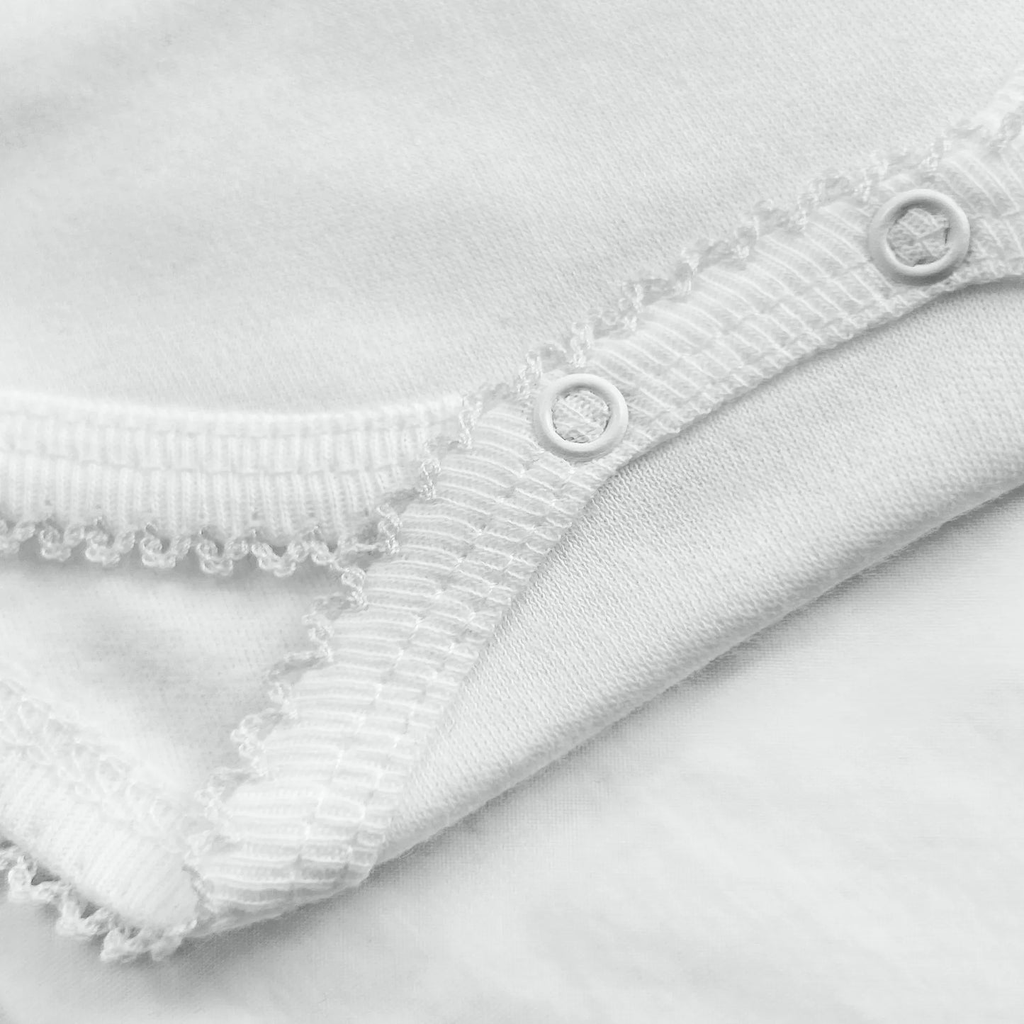 Pormenor de body de trespasse com collant cardado com bordado em redor branco