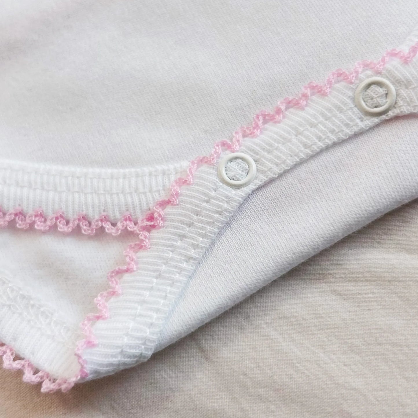 Pormenor de body de trespasse com collant cardado com bordado em redor rosa