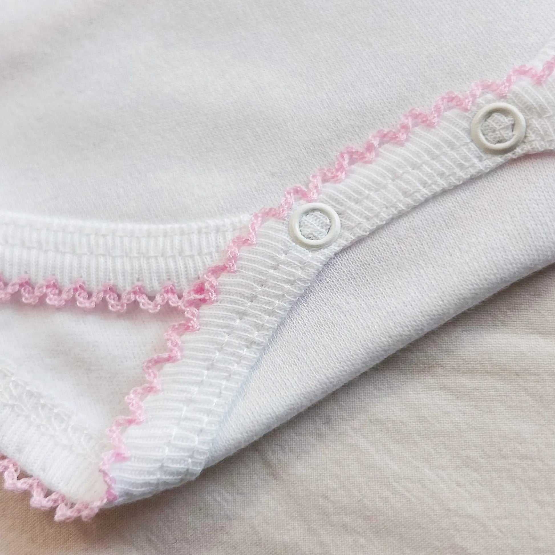 Pormenor de body de trespasse com collant cardado com bordado em redor rosa