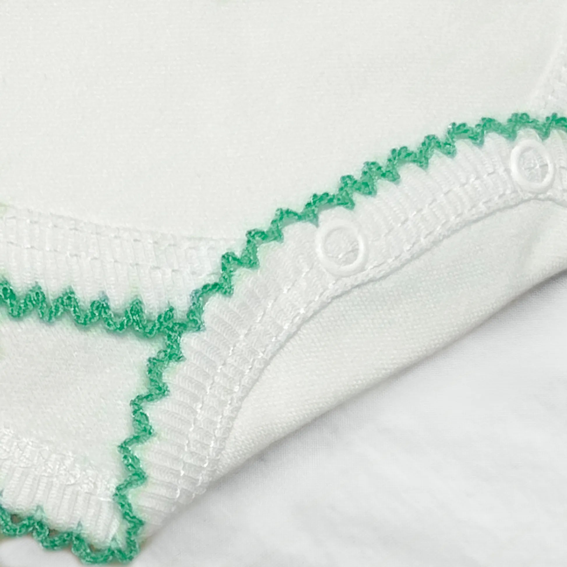 Pormenor de body de trespasse com collant cardado com bordado em redor verde