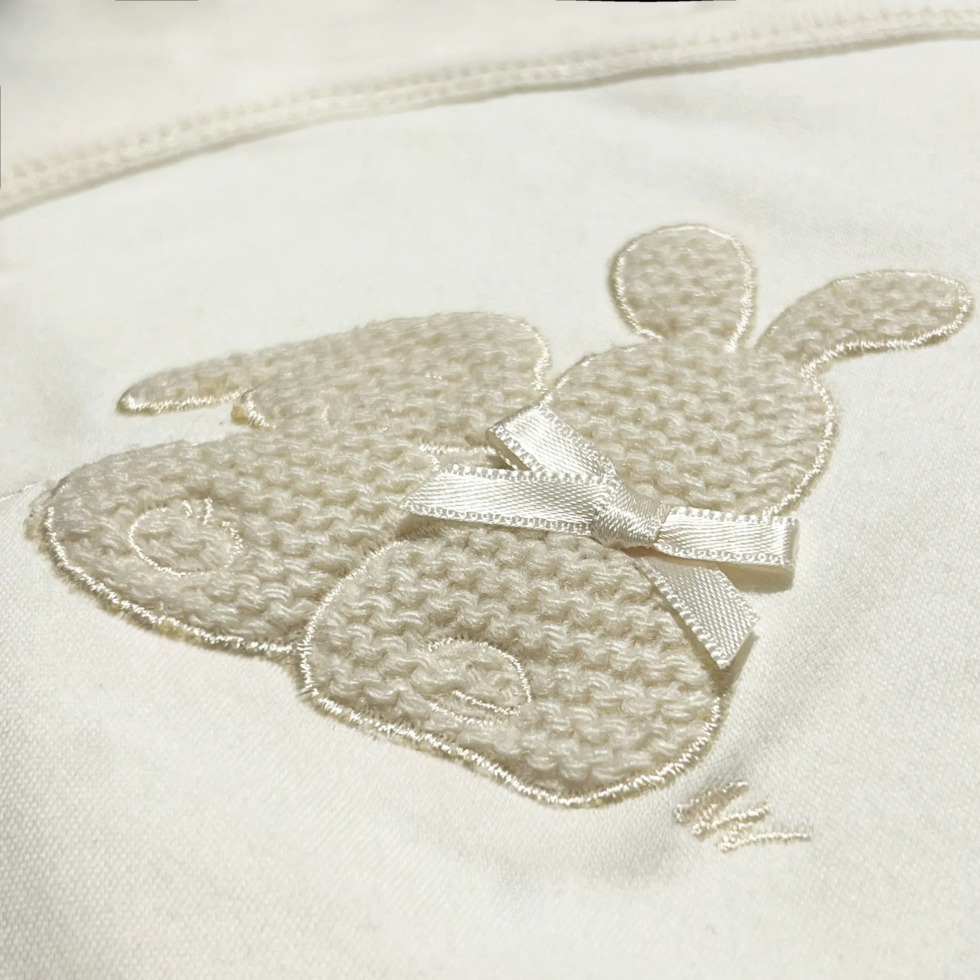 Pormenor de body de trespasse com collant cardado com motivo coelhos tricot com lacinho bege