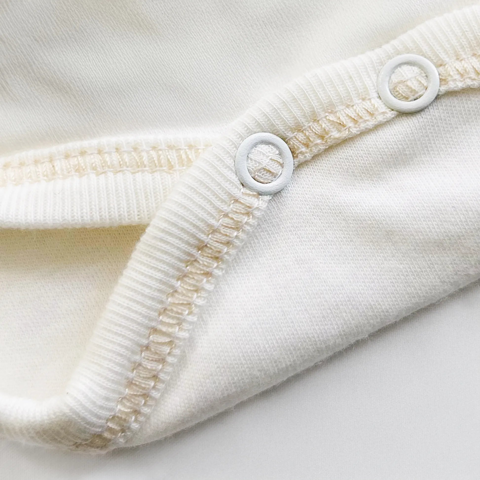 Pormenor de body de trespasse com collant cardado com motivo coelhos tricot com lacinho bege