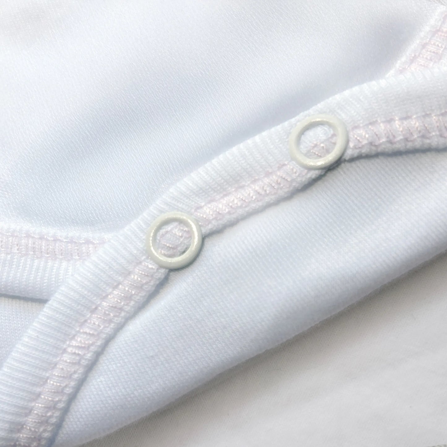 Pormenor de body de trespasse com collant cardado com motivo coelhos tricot com lacinho rosa