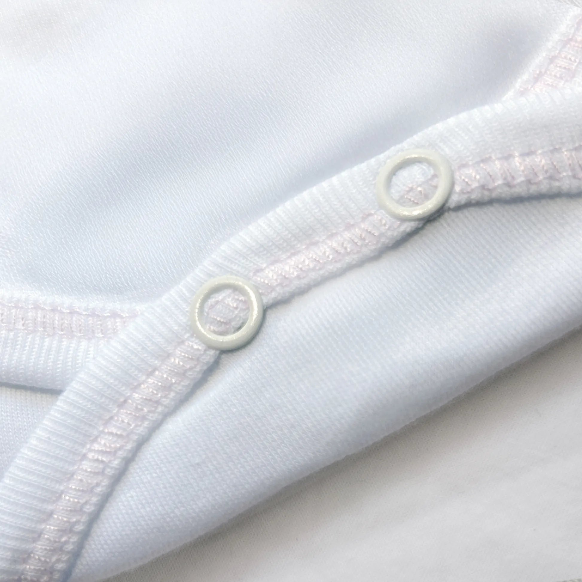 Pormenor de body de trespasse com collant cardado com motivo coelhos tricot com lacinho rosa