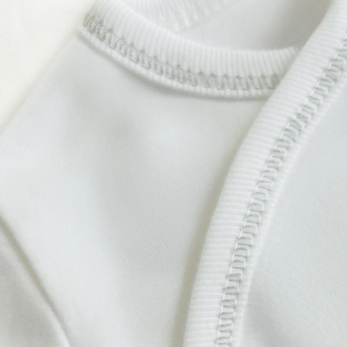 Pormenor de body de trespasse com collant cardado com motivo ursinhos tricot e lacinho cinza