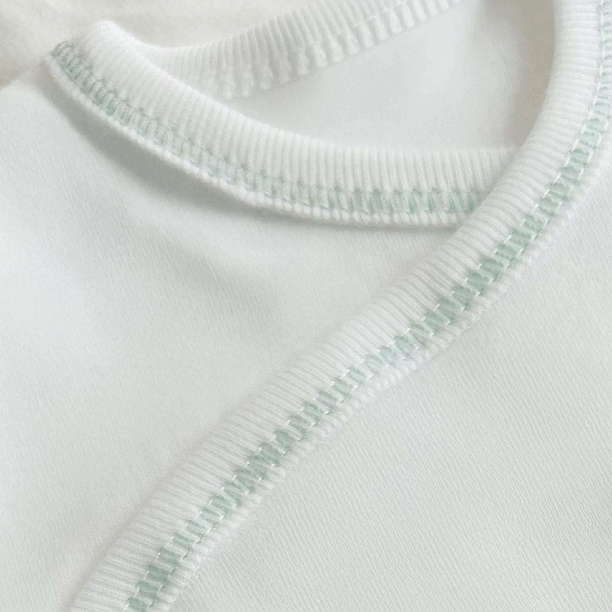 Pormenor de body de trespasse com collant cardado com motivo ursinhos tricot e lacinho verde
