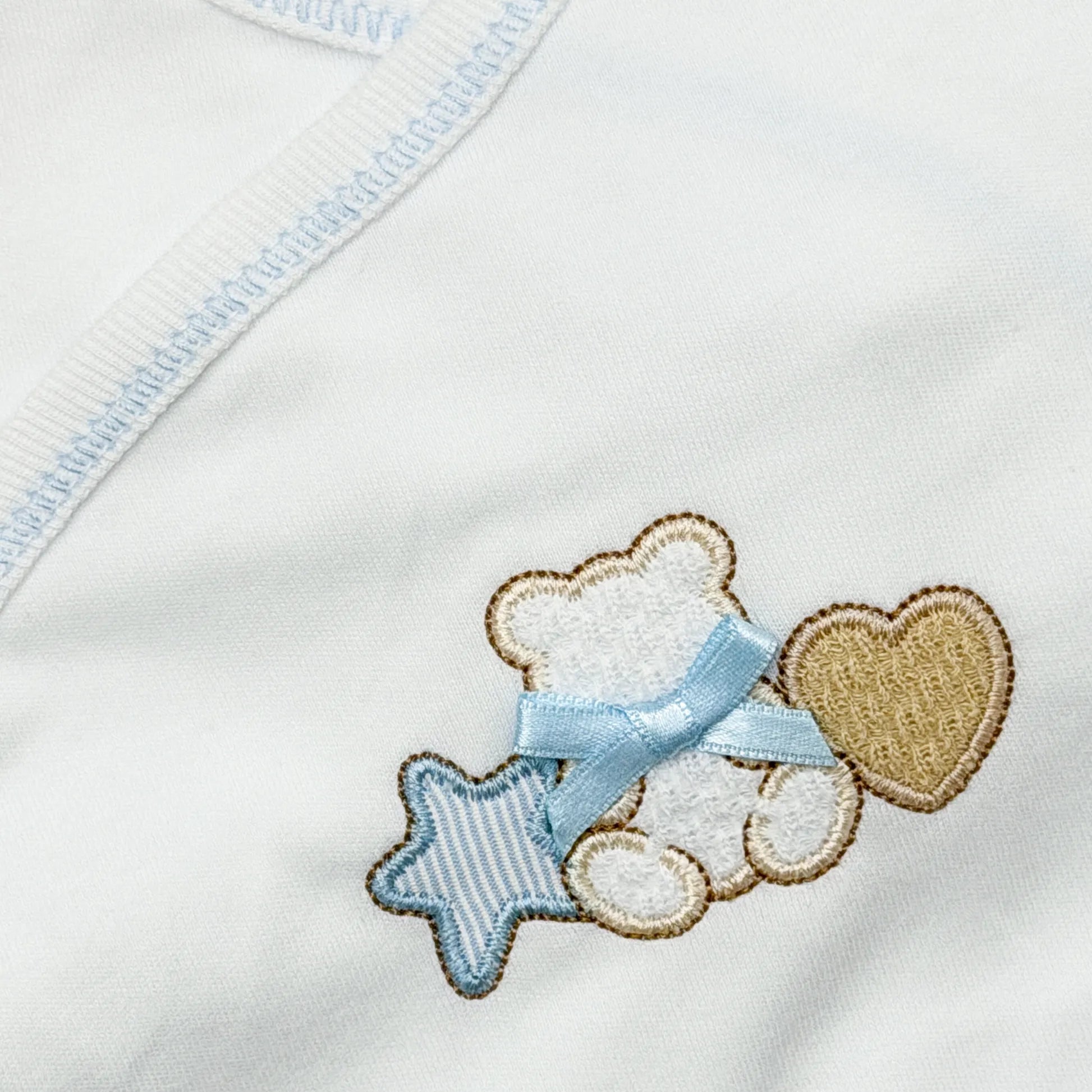 Pormenor de body de trespasse com collant com motivo ursinho entre estrela e coração azul