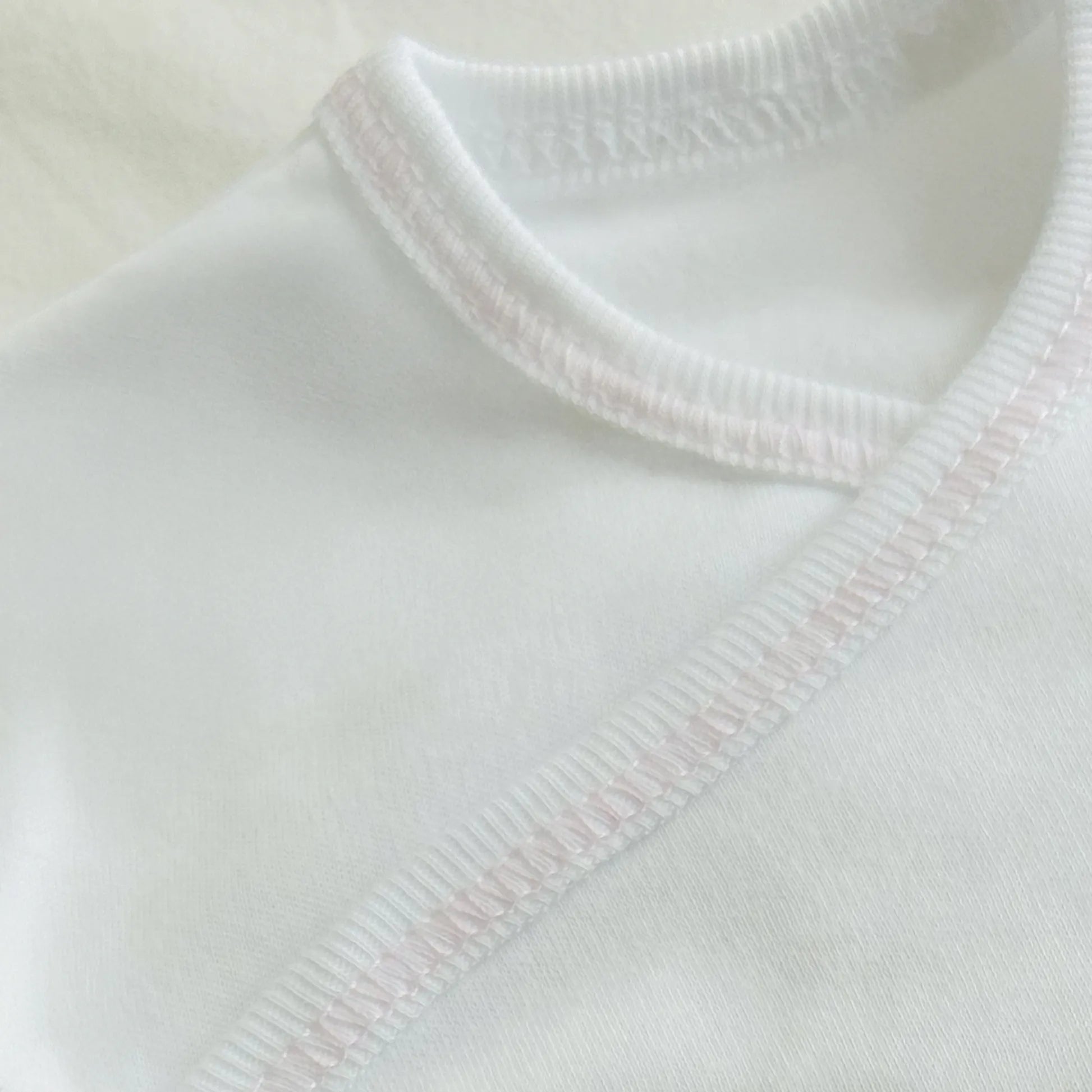 Pormenor de body de trespasse com collant com motivo ursinhos com pintas rosa
