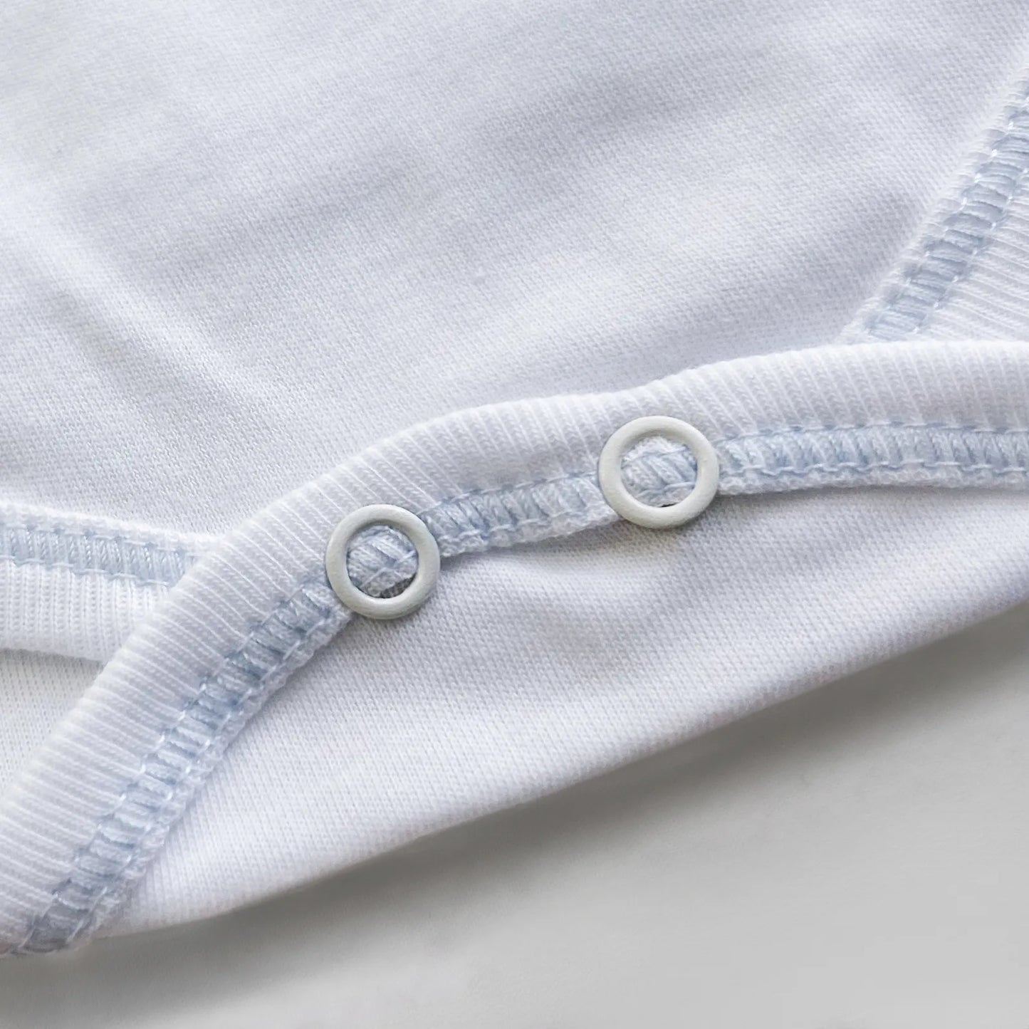 Pormenor de body de trespasse com collants com bordado pintas azul