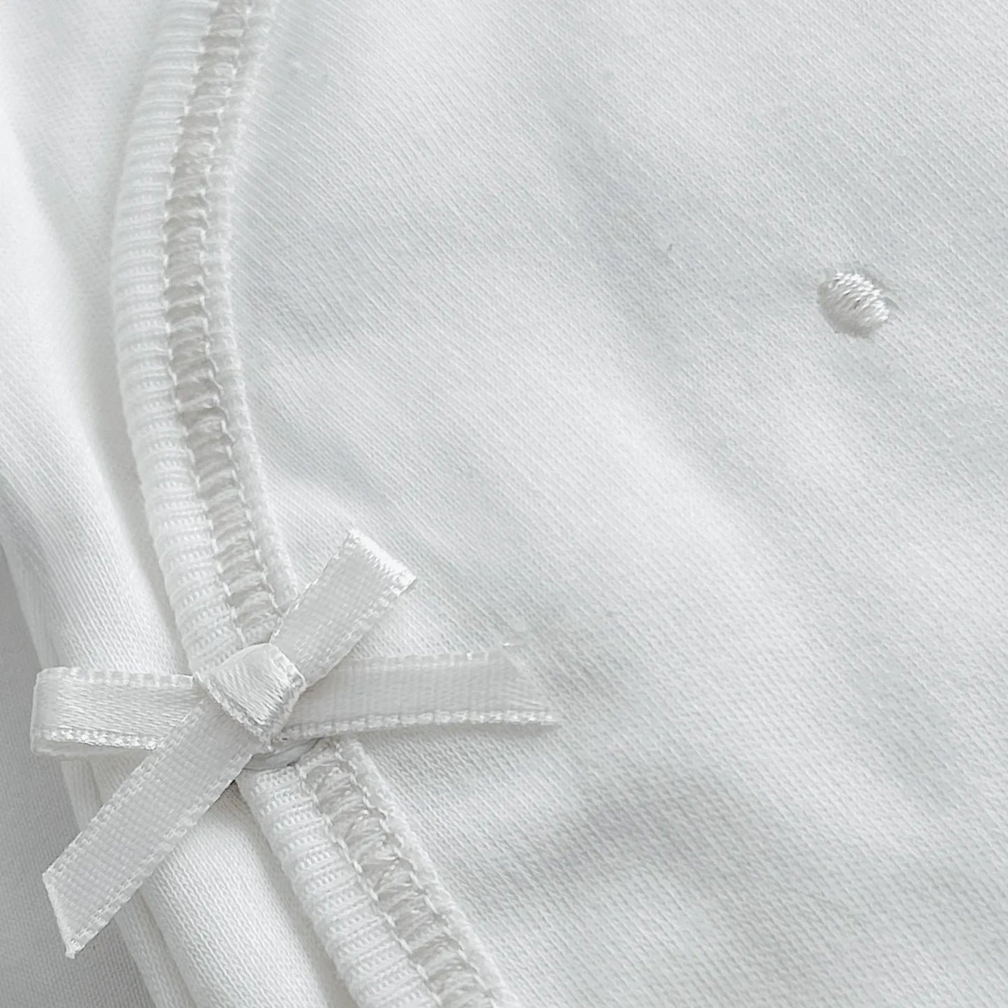 Pormenor de body de trespasse com collants com bordado pintas branco