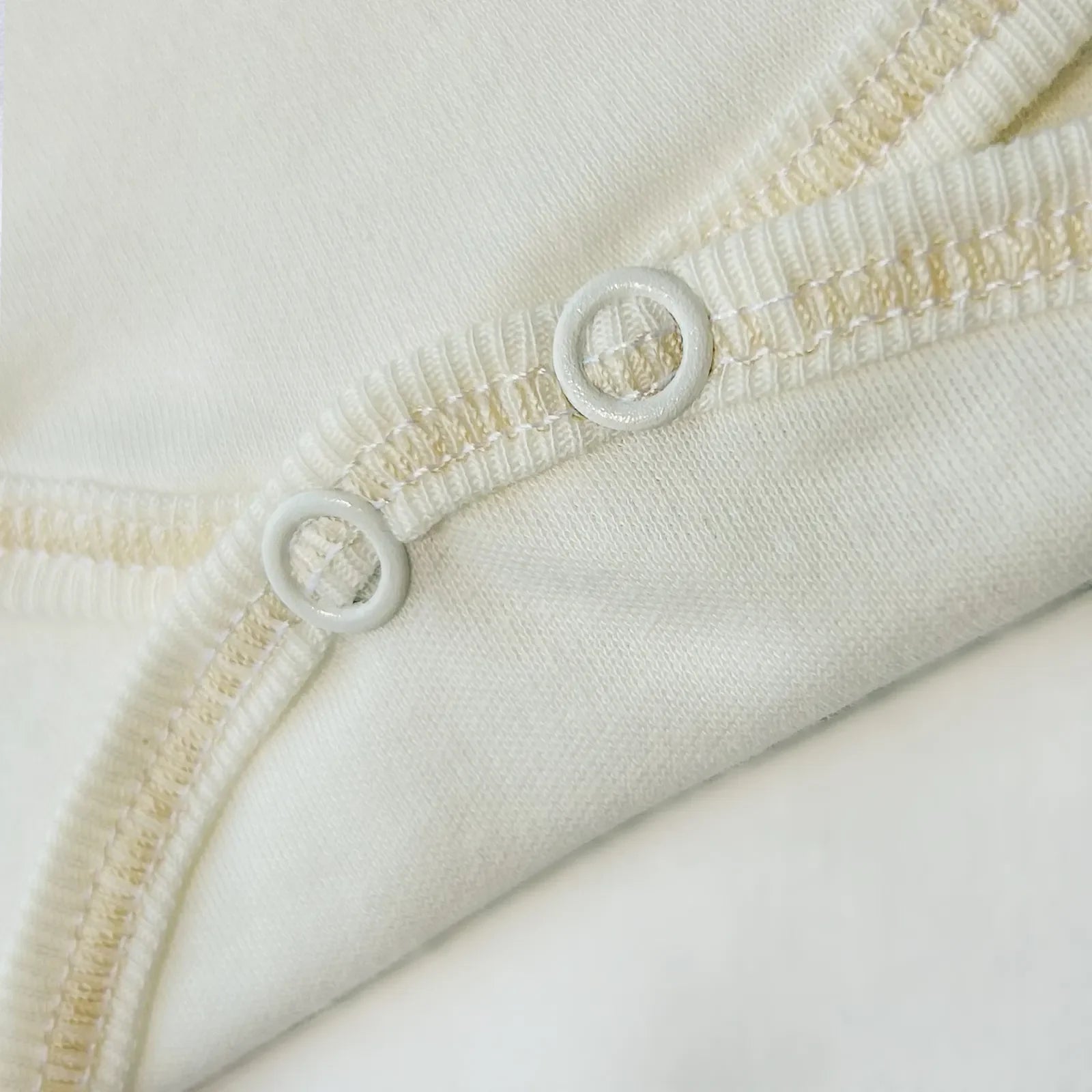 Pormenor de body de trespasse com collants pérola com bordado pintas