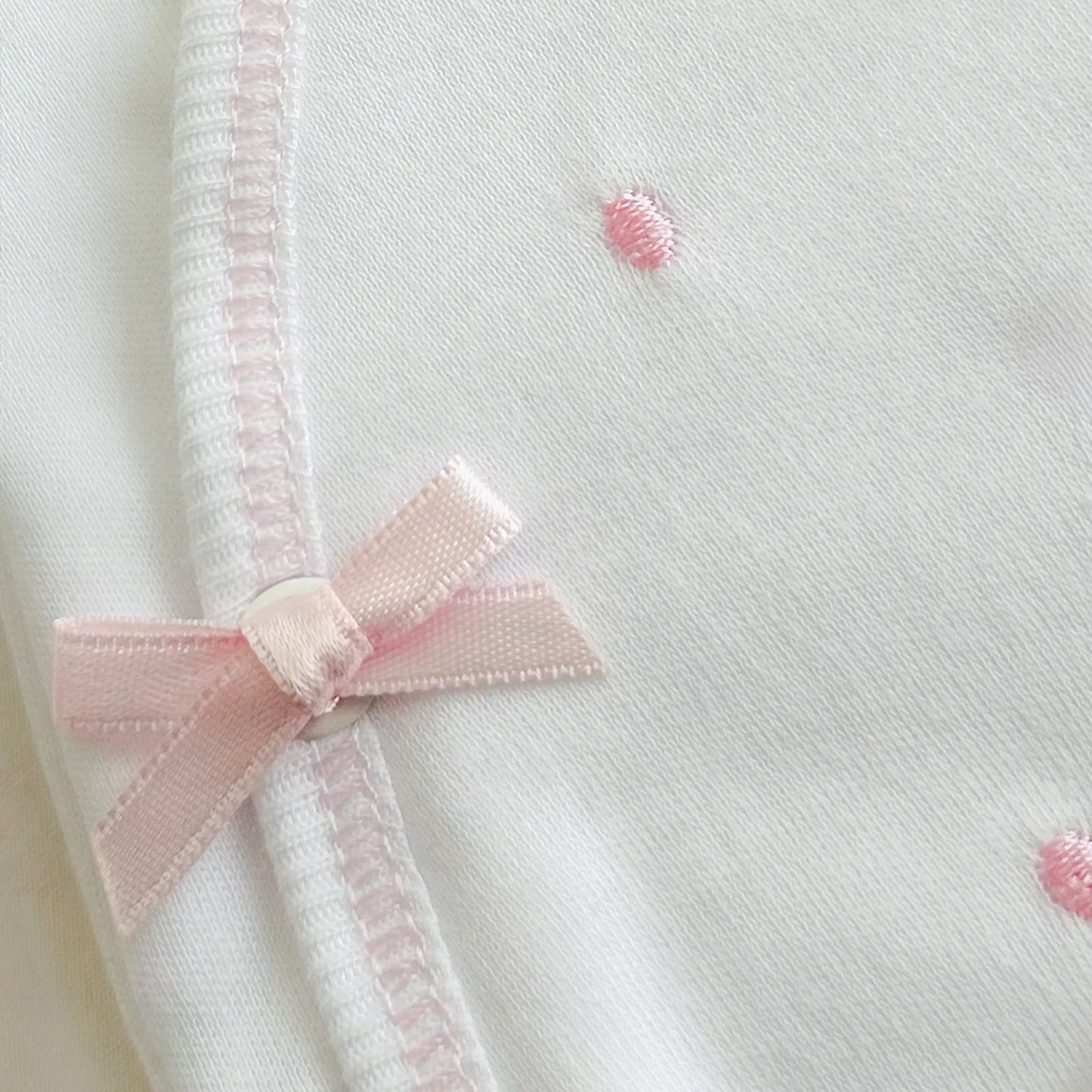 Pormenor de body de trespasse com collants com bordado pintas rosa