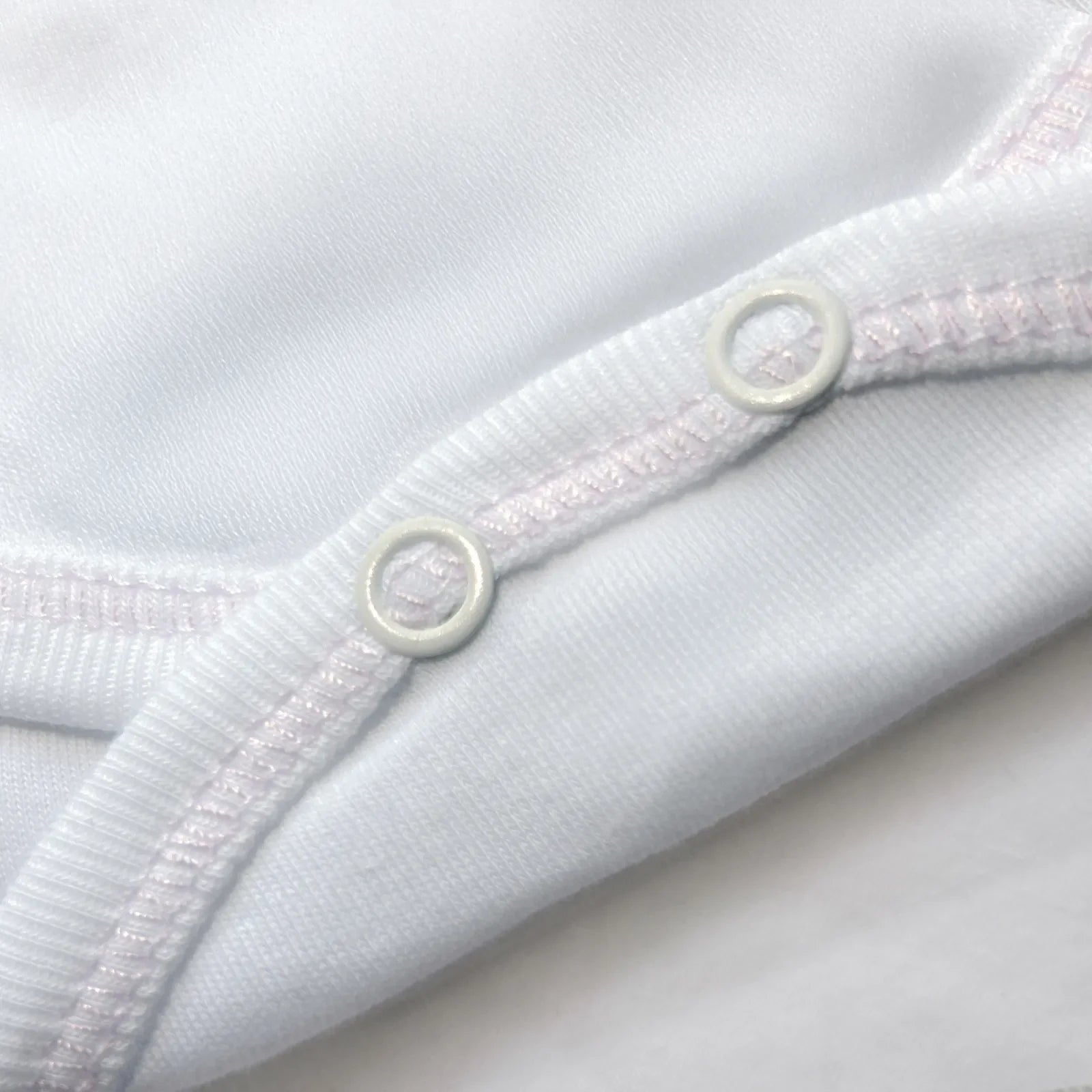 Pormenor de body de trespasse com collants com bordado pintas rosa