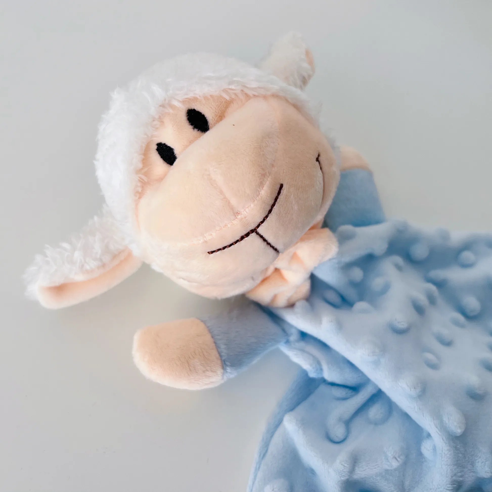 Doudou do conjunto de manta e doudou ovelha com detalhes em relevo azul