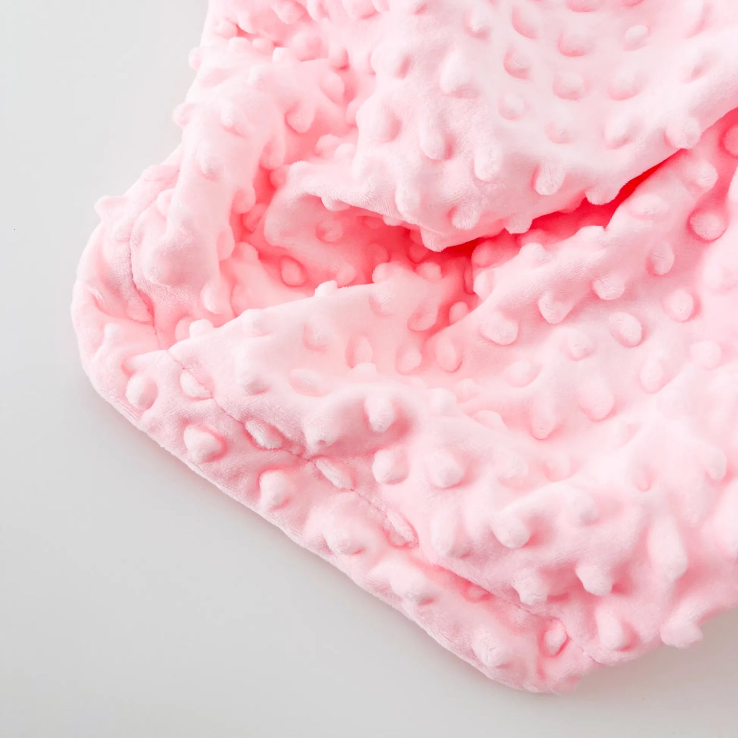 Pormenor de conjunto de manta e doudou ovelha com detalhes em relevo rosa
