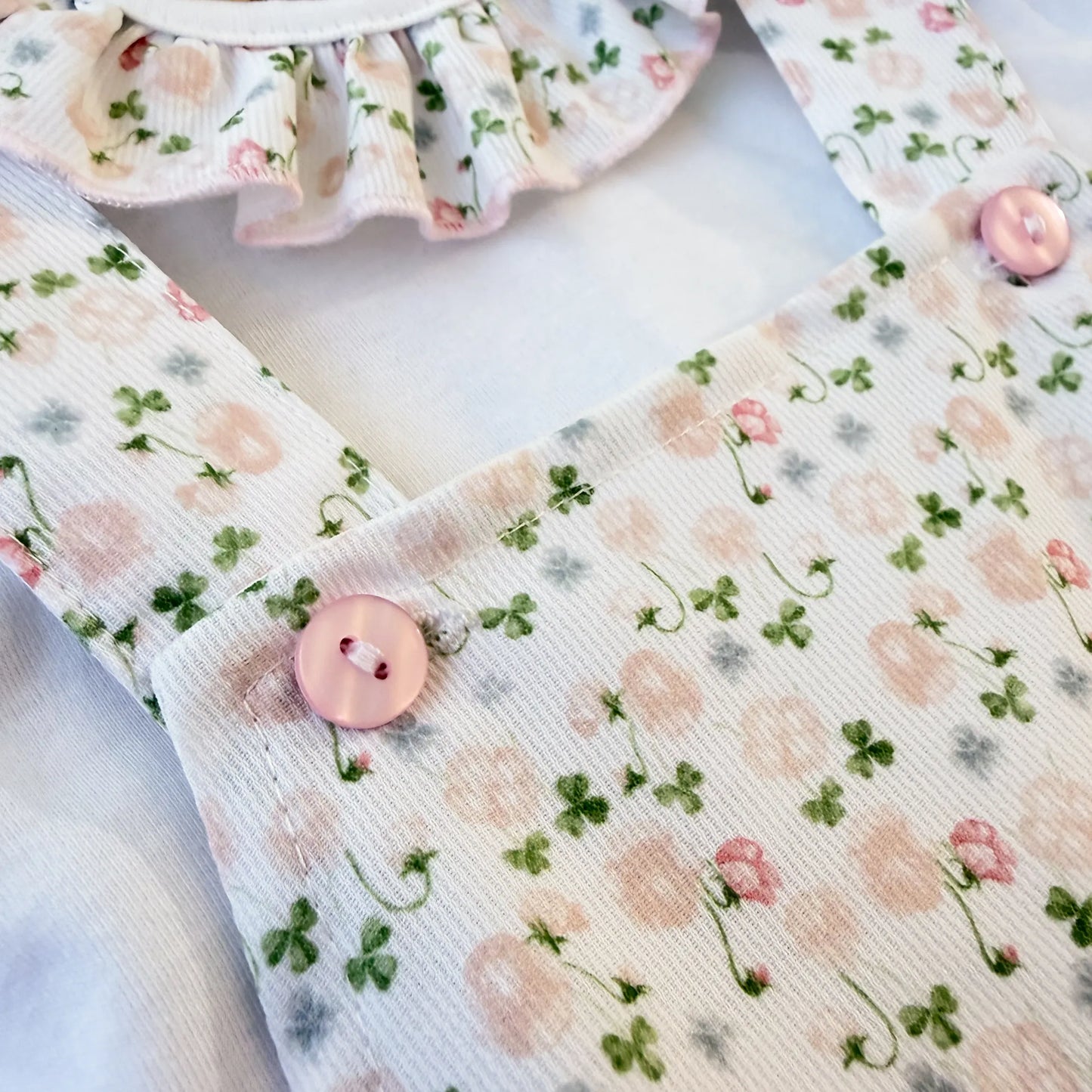 Detalhe de conjunto de menina de jardineira e camisola com padrão florido