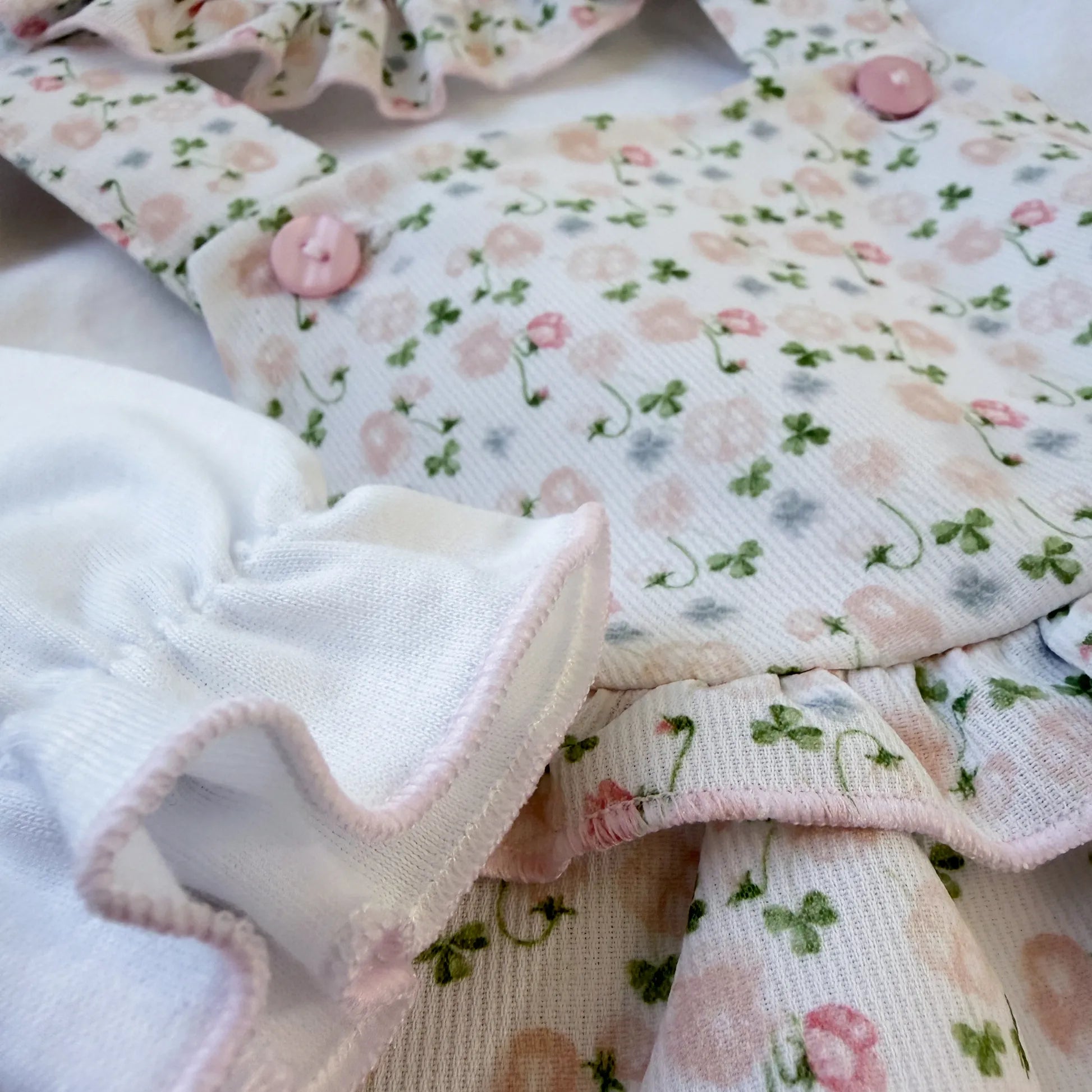 Detalhe de conjunto de menina de jardineira e camisola com padrão florido