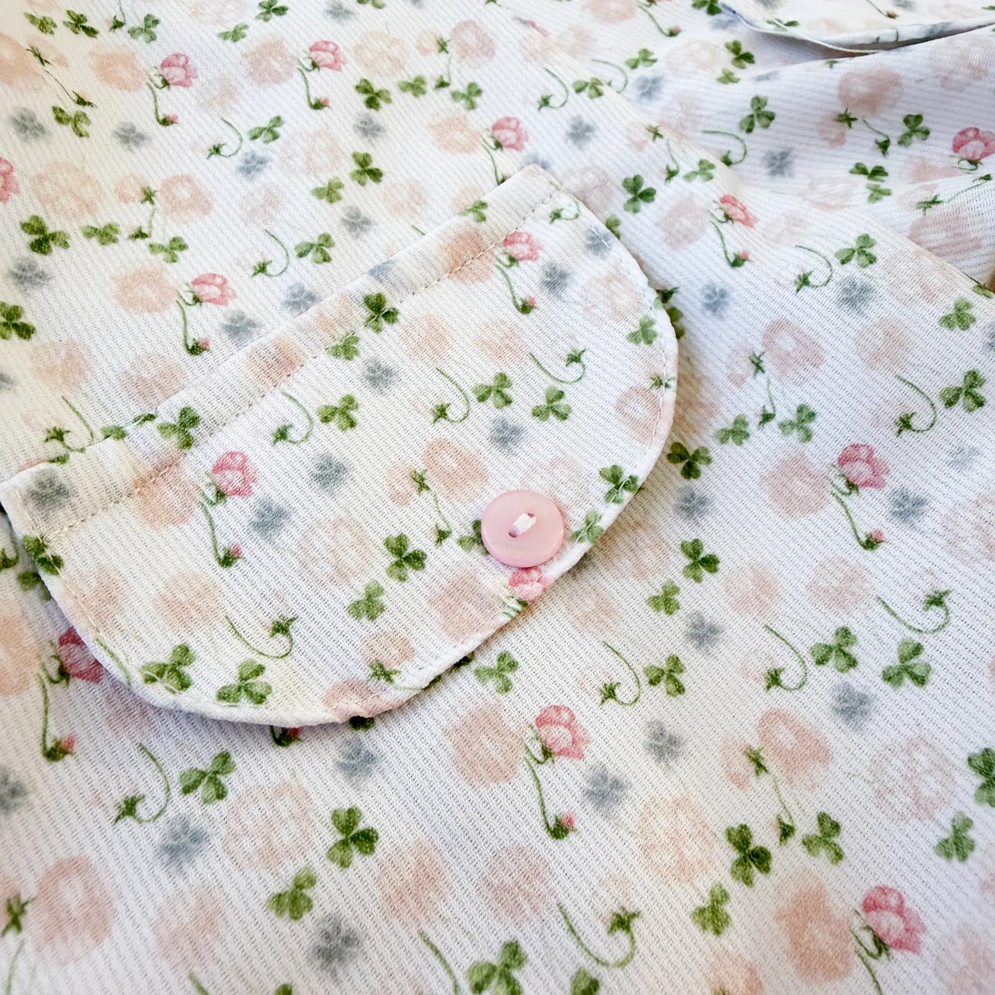 Detalhe de conjunto de menina de jardineira e camisola com padrão florido