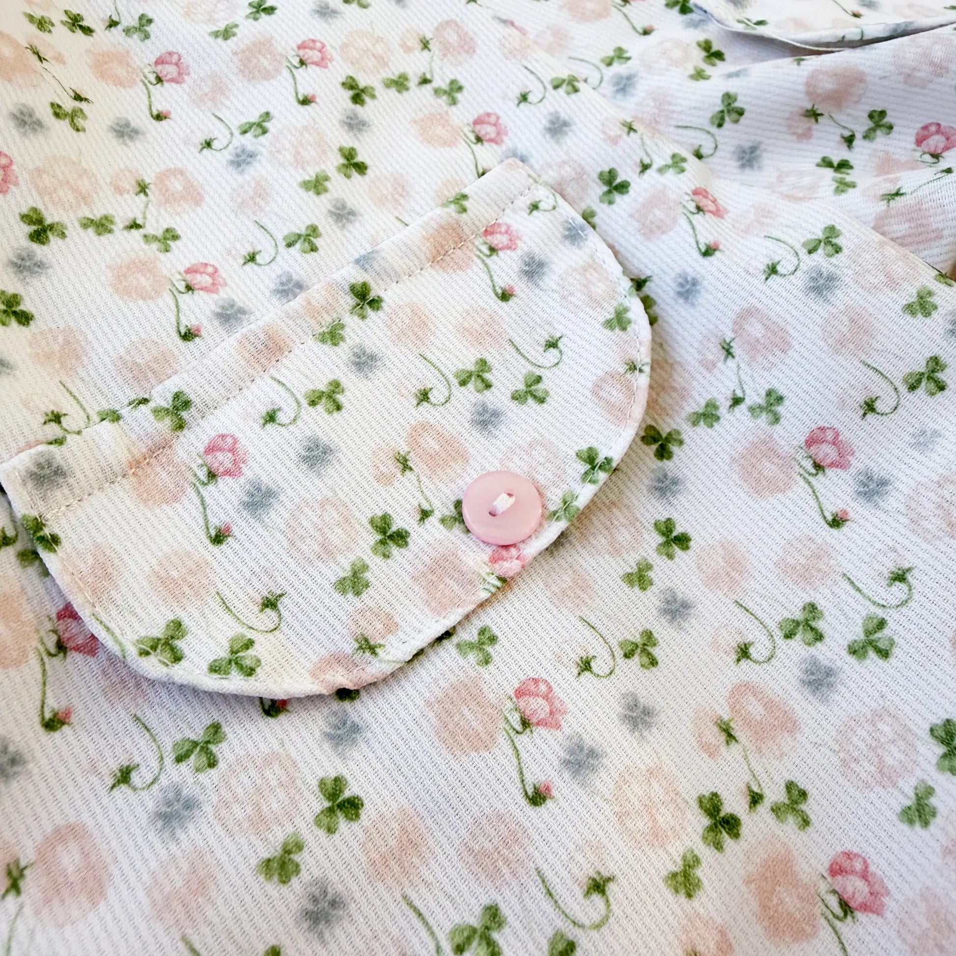 Detalhe de conjunto de menina de jardineira e camisola com padrão florido