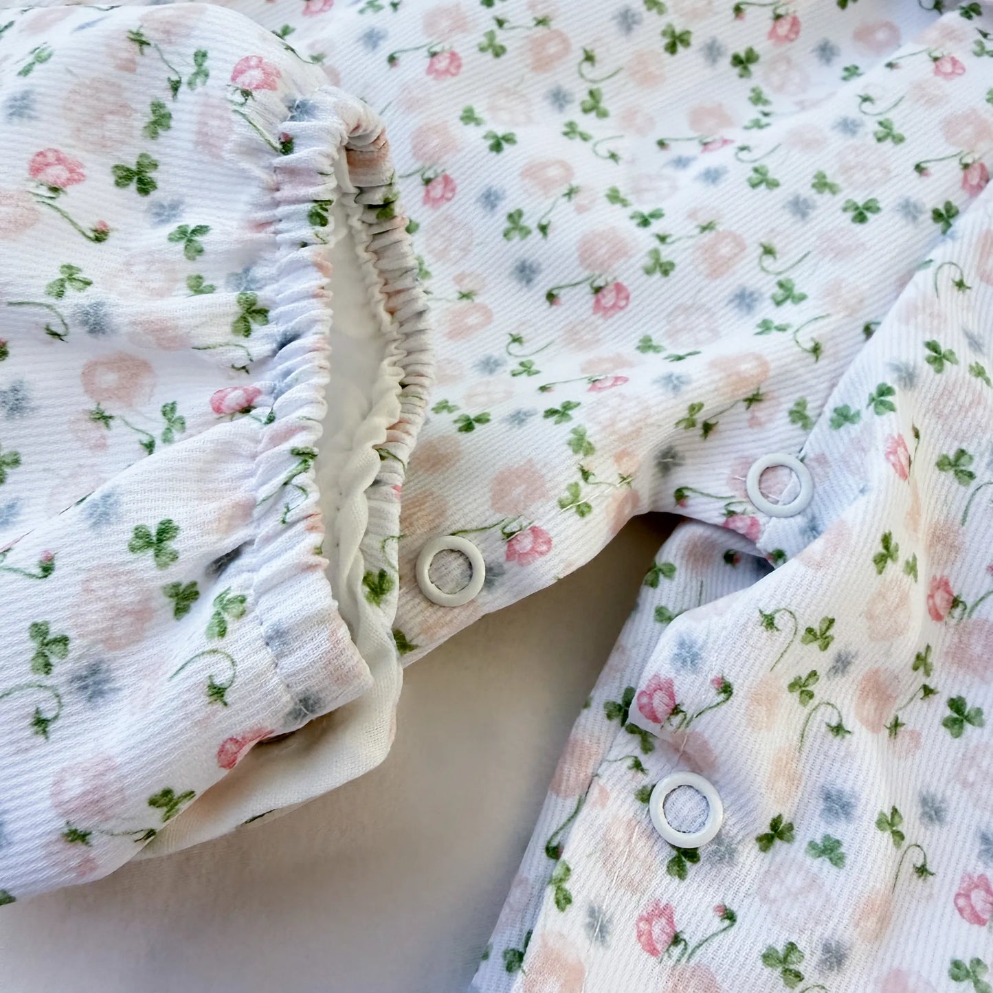 Detalhe de conjunto de menina de jardineira e camisola com padrão florido
