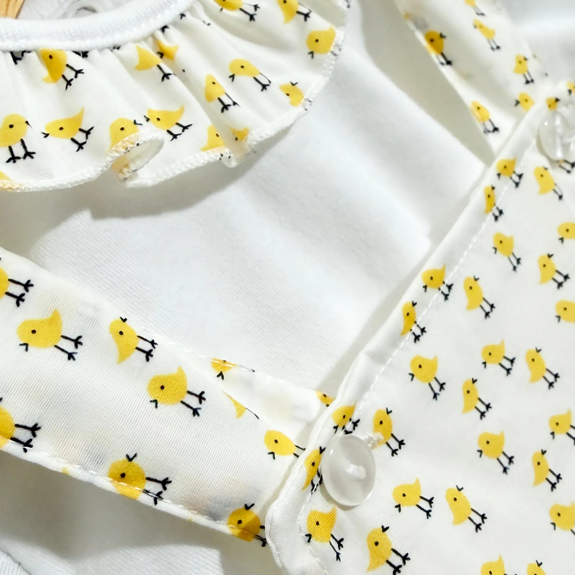 Detalhes de conjunto de menina de jardineira e camisola com padrão de pintainhos amarelo