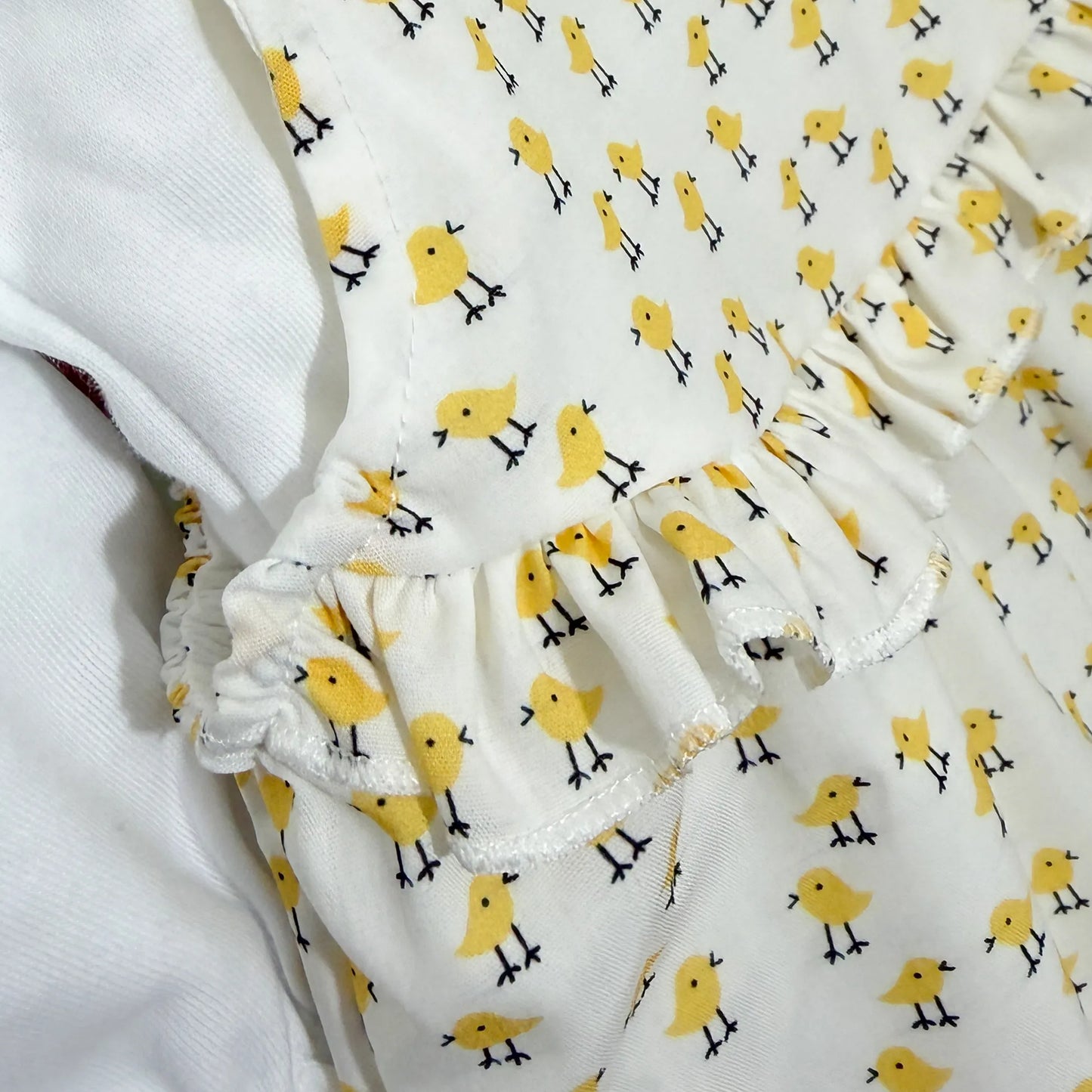 Detalhes de conjunto de menina de jardineira e camisola com padrão de pintainhos amarelo