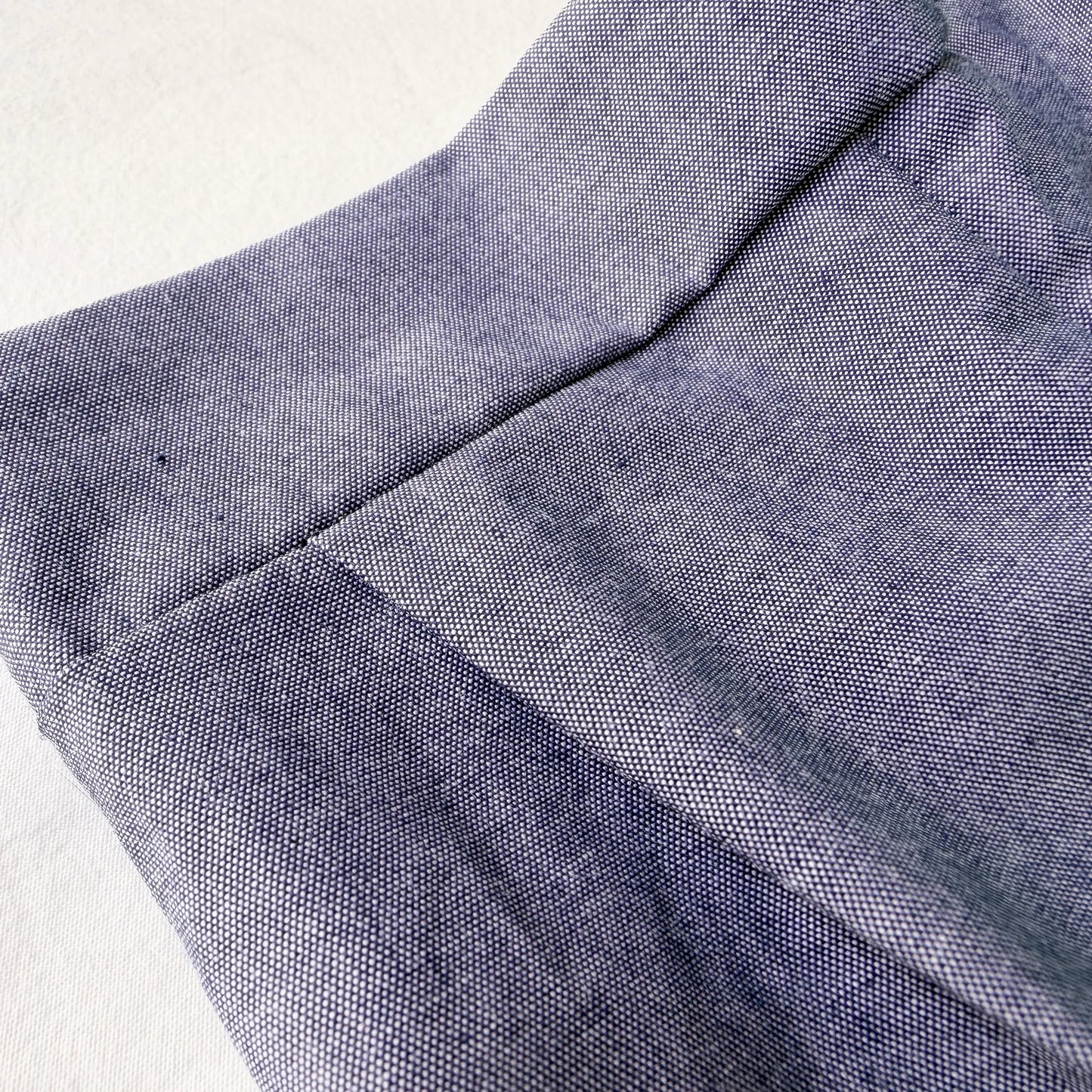 Pormenor de conjunto de menino de T-shirt com botões e calção de tecido marinho