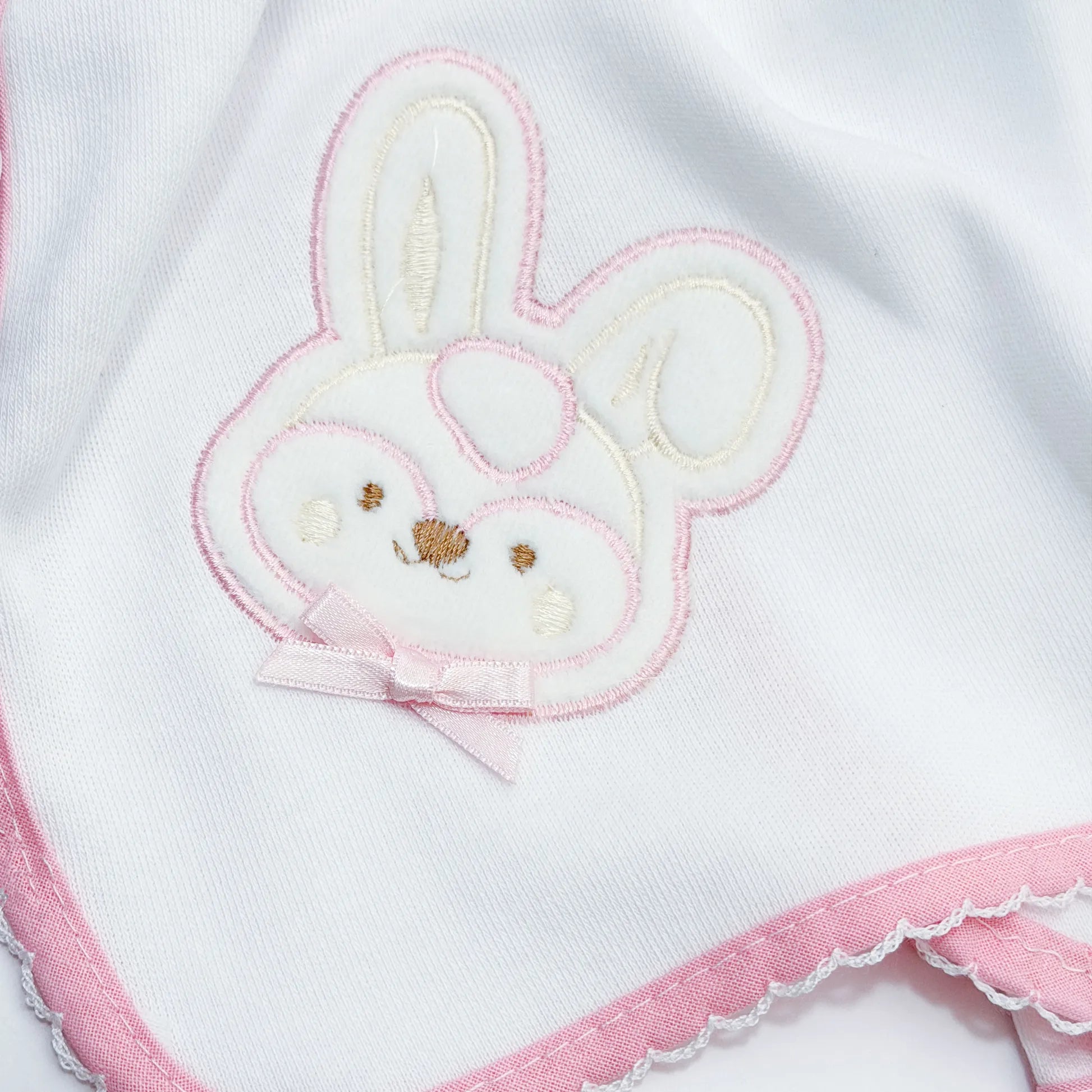 Pormenor de fralda com motivo coelho em relevo rosa