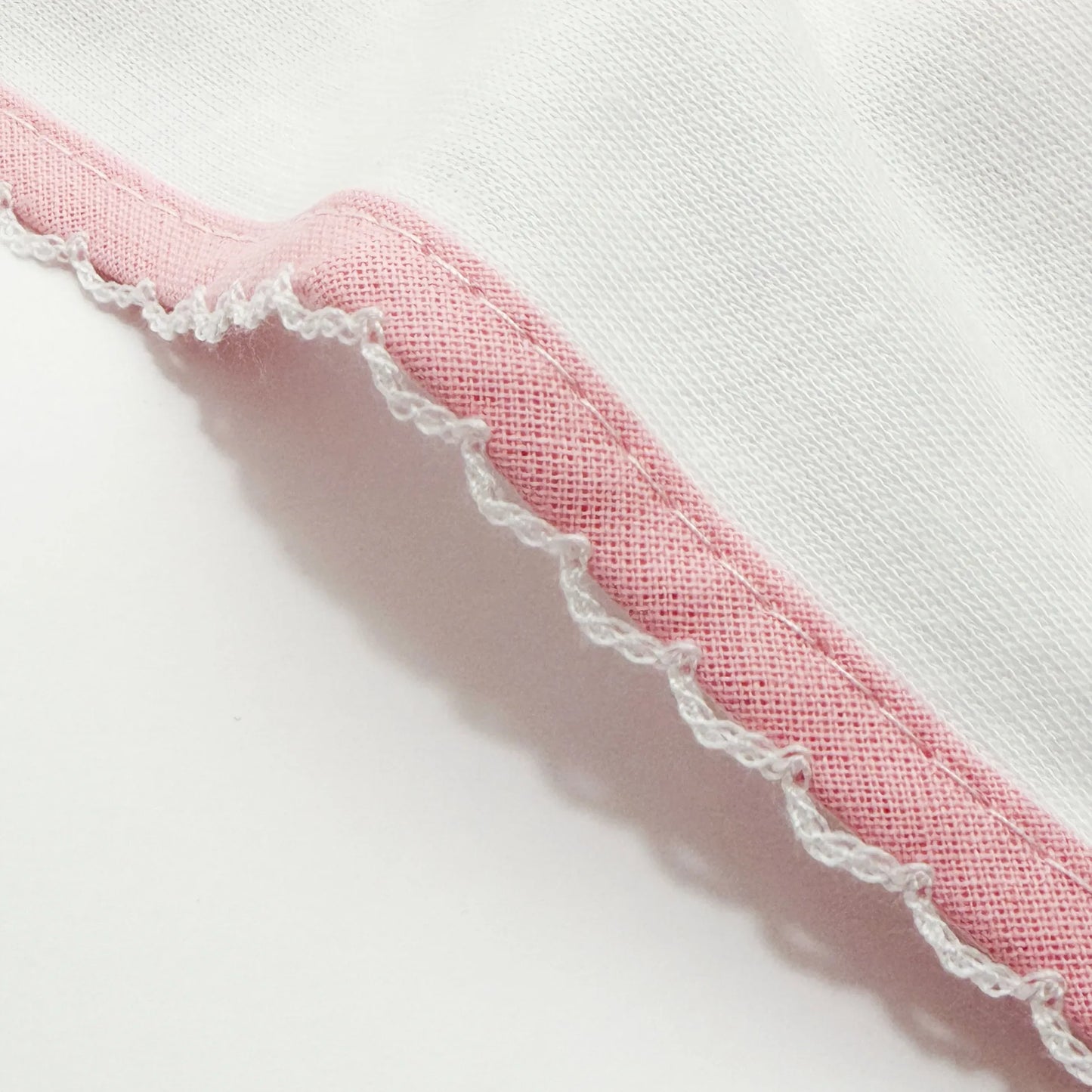 Pormenor de fralda com motivo coelho em relevo rosa