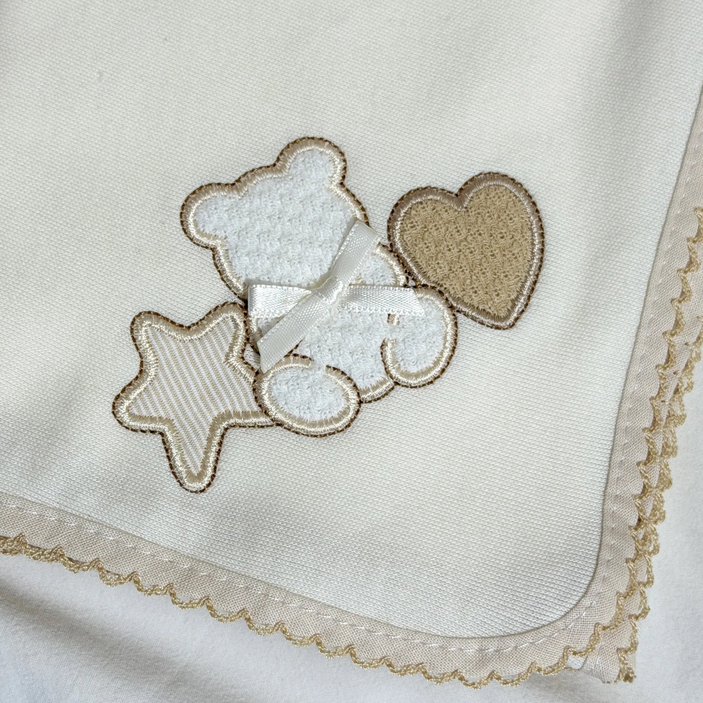 Pormenor de fralda com motivo ursinho entre estrela e coração pérola