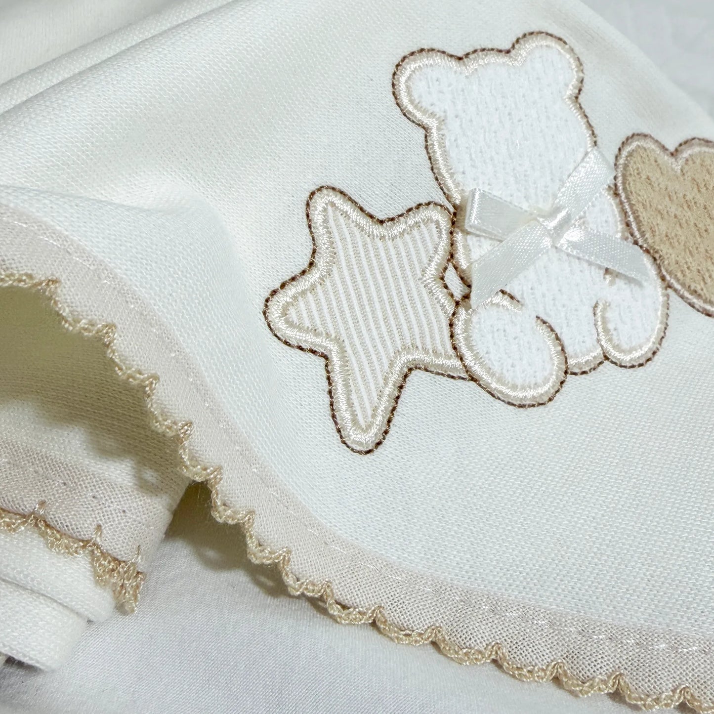 Pormenor de fralda com motivo ursinho entre estrela e coração pérola